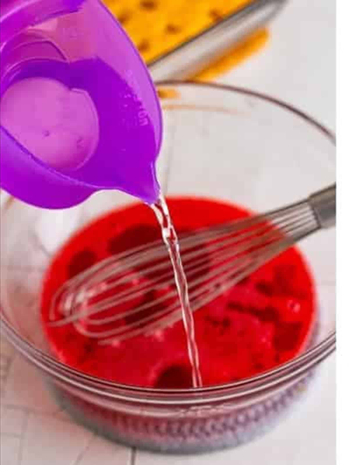 Whisking the strawberry jello with cold water for poke cake.