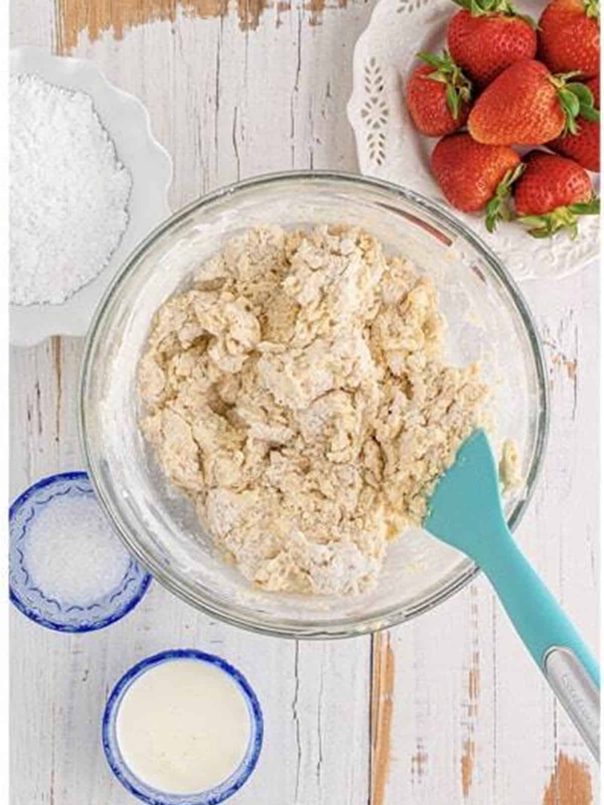 Scone dough mixed together in a glass bowl.
