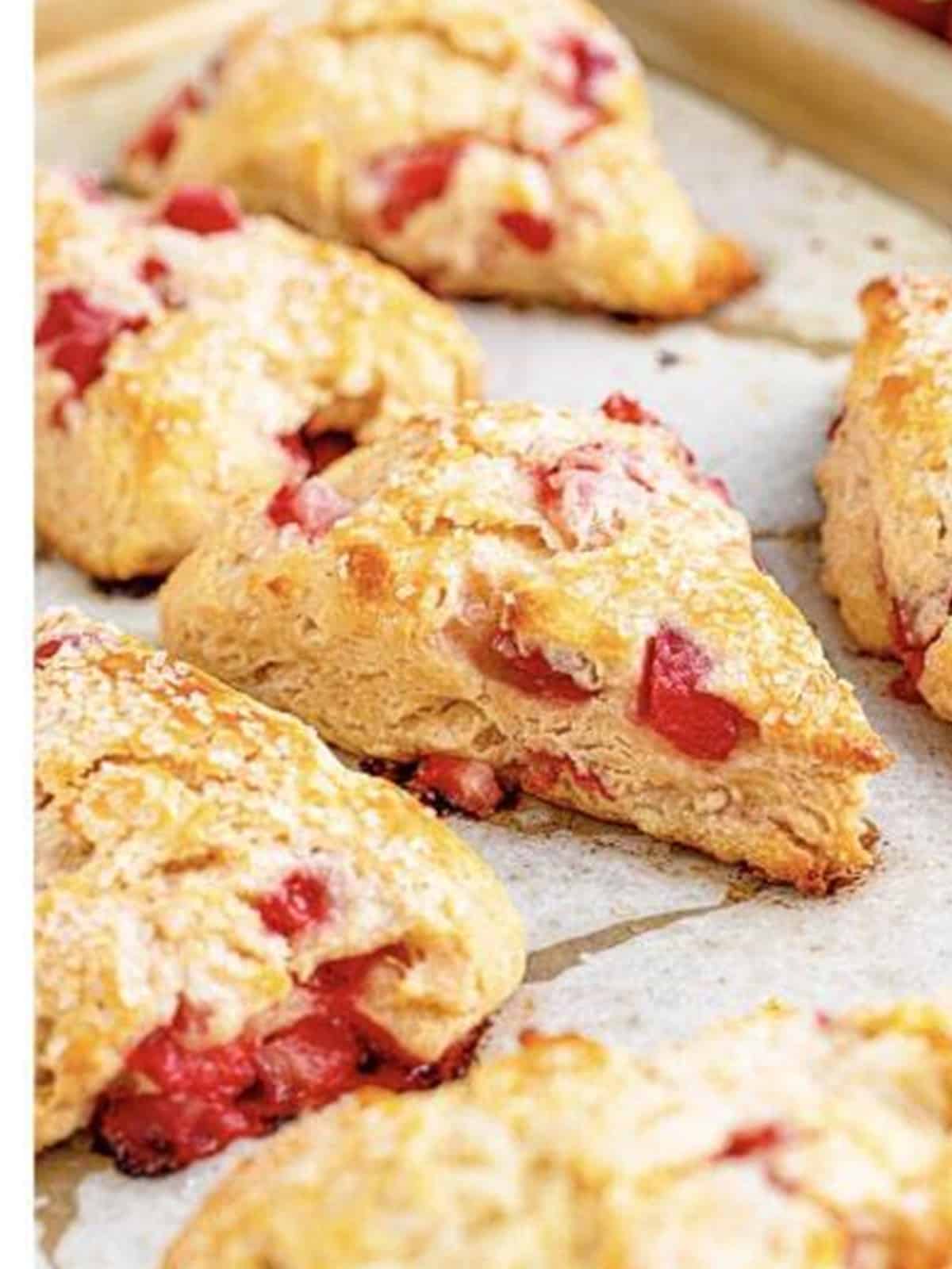 Golden baked strawberry scones on a sheet tray.