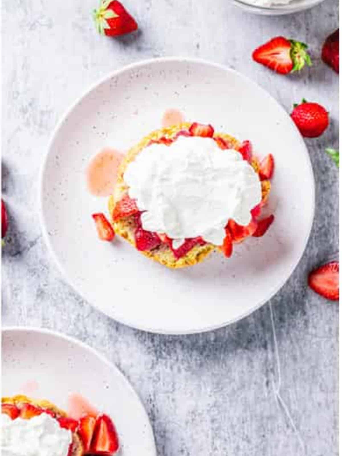 Split shortcake biscuit layered with macerated strawberries and whipped cream.