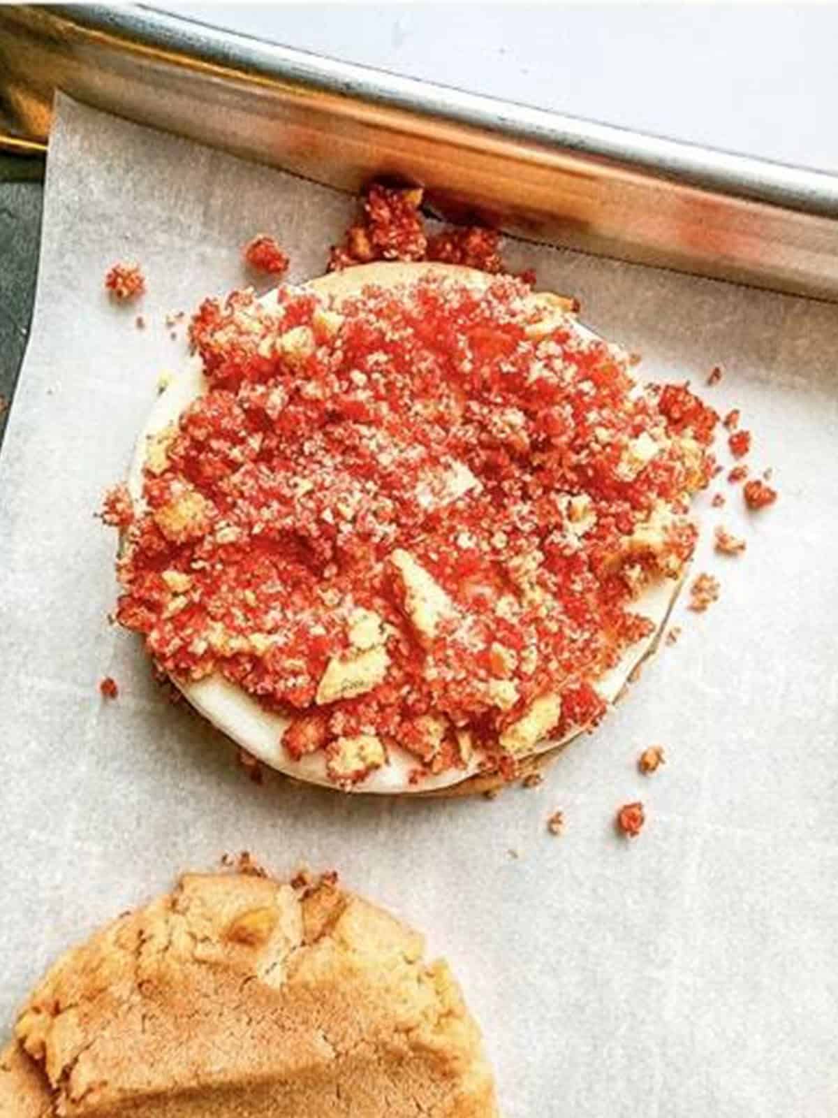 Strawberry shortcake cookie topped with cream cheese frosting and strawberry crunch.