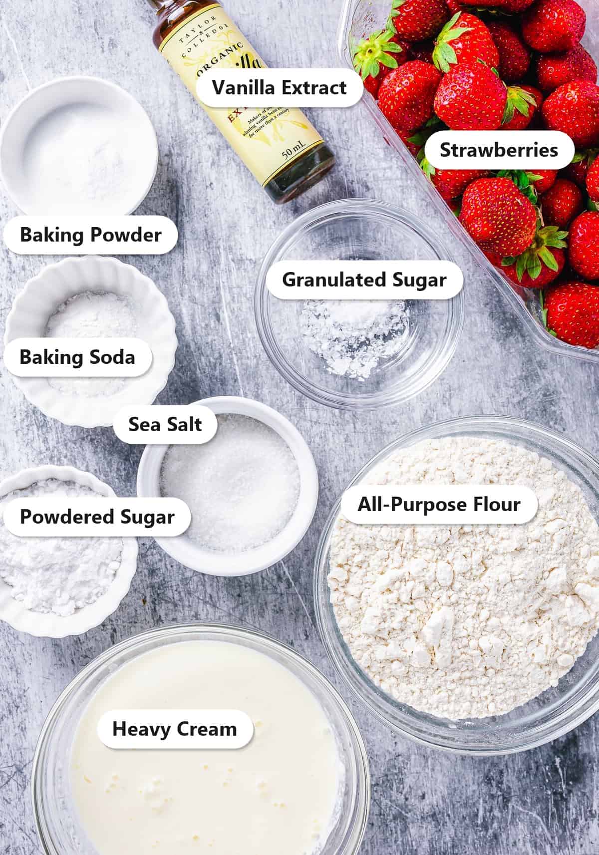 Labeled ingredients for strawberry shortcake including strawberries, all-purpose flour, heavy cream, granulated sugar, baking powder, baking soda, sea salt, and vanilla extract.