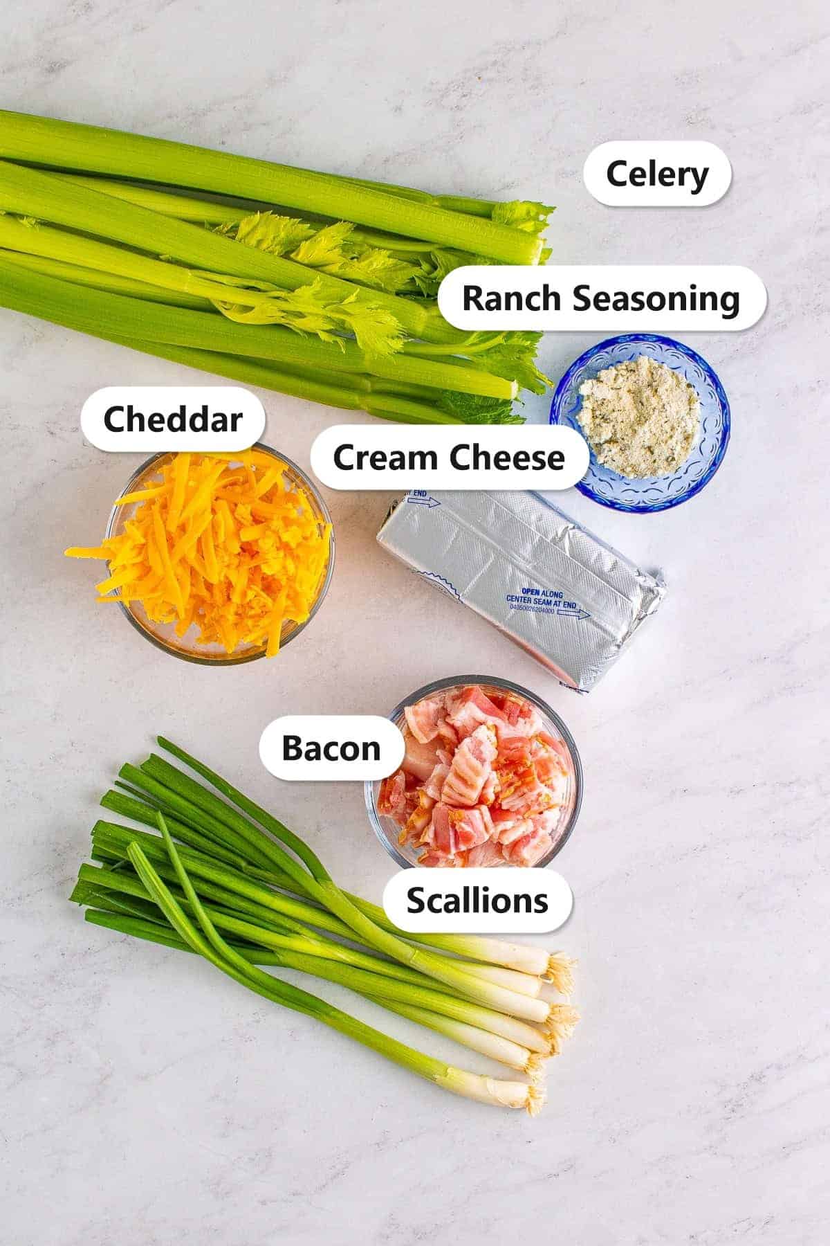 Labeled ingredients for cheddar bacon ranch stuffed celery sticks including celery, bacon, cream cheese, sharp cheddar, ranch seasoning, and scallions.