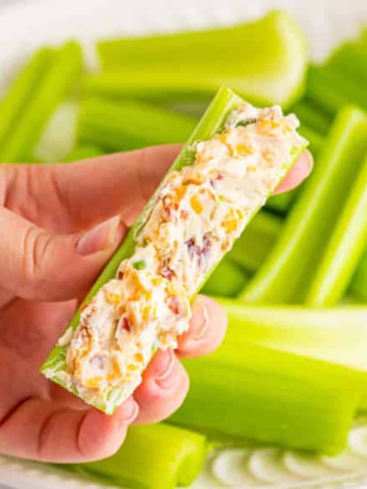 The cheddar bacon ranch filling spread into a celery stick with a butter knife.