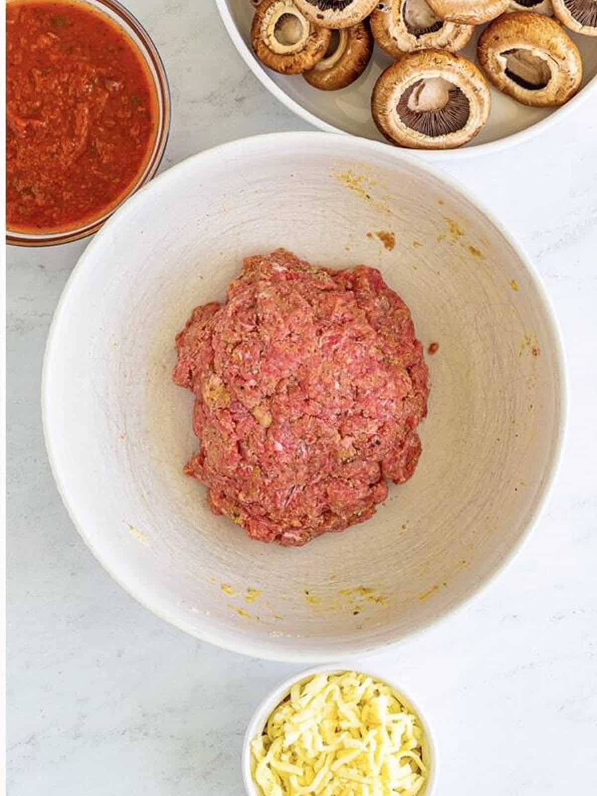 Italian meatball mixture combined in a bowl for stuffed mushrooms.