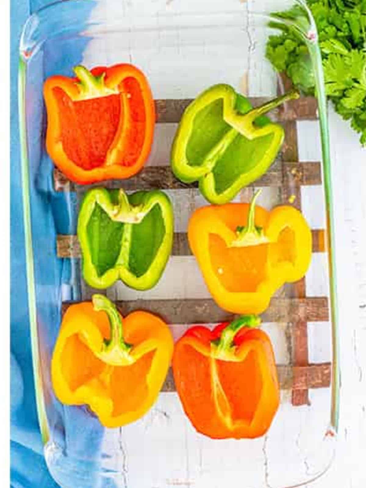 Bell peppers cut in half and seeded in a baking dish for stuffed peppers.