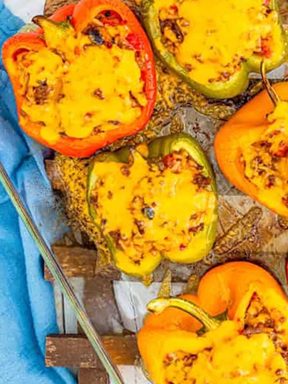 Stuffed peppers topped with shredded cheese before baking.