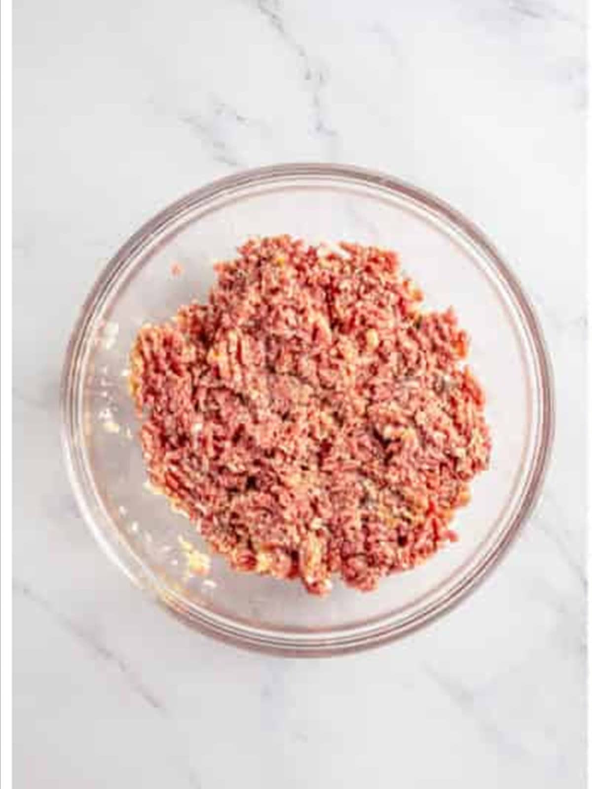 Mixing ground beef and pork with breadcrumbs and spices for Swedish meatballs.