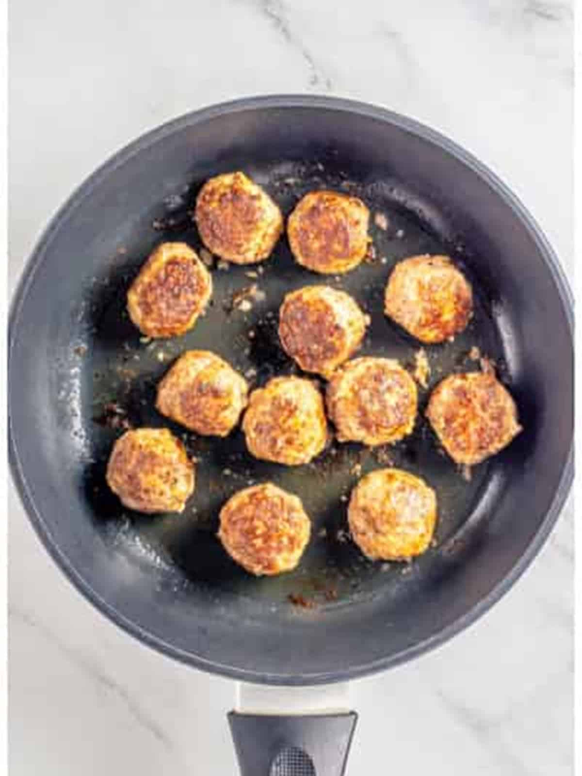 Browning Swedish meatballs in a skillet until golden.