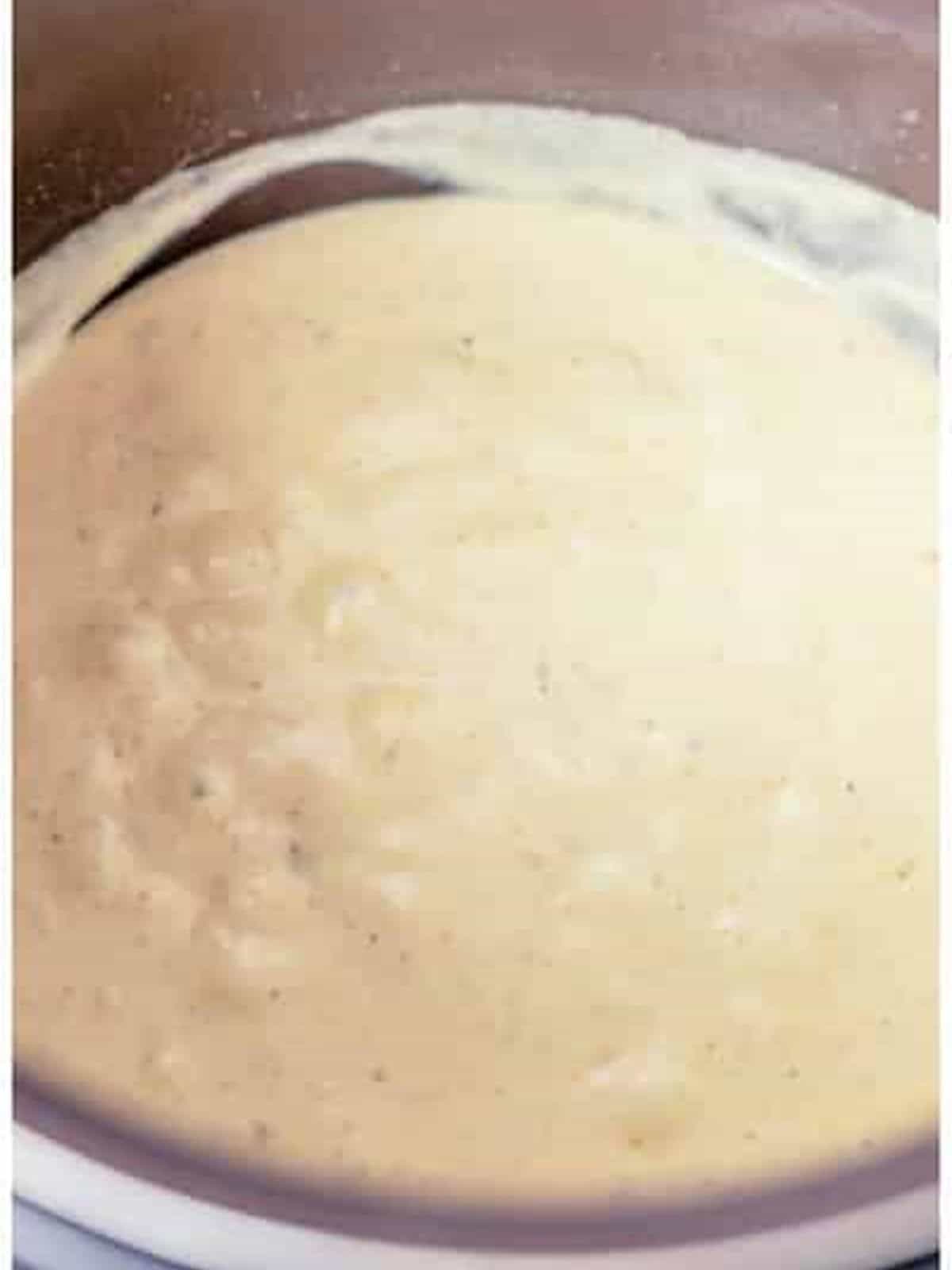 Creamy thickened sauce in the slow cooker for Swedish meatballs.
