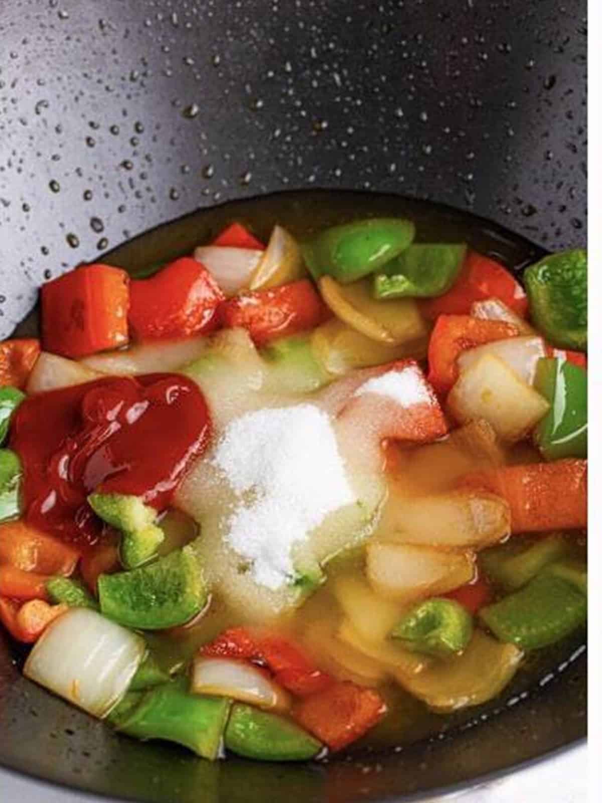 Sweet and sour sauce ingredients added to the wok with the stir-fried vegetables.