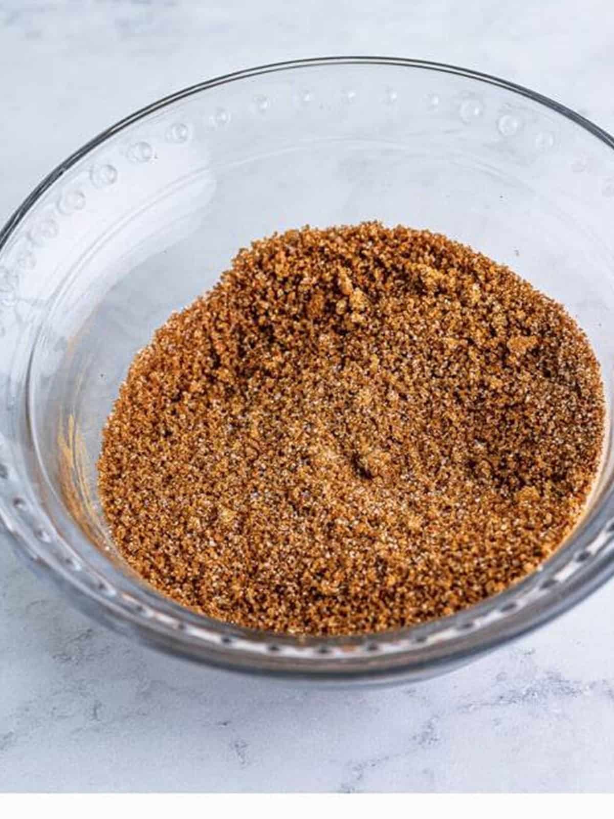 Cinnamon sugar topping mixed together in a glass bowl for Sweet Chex Mix.