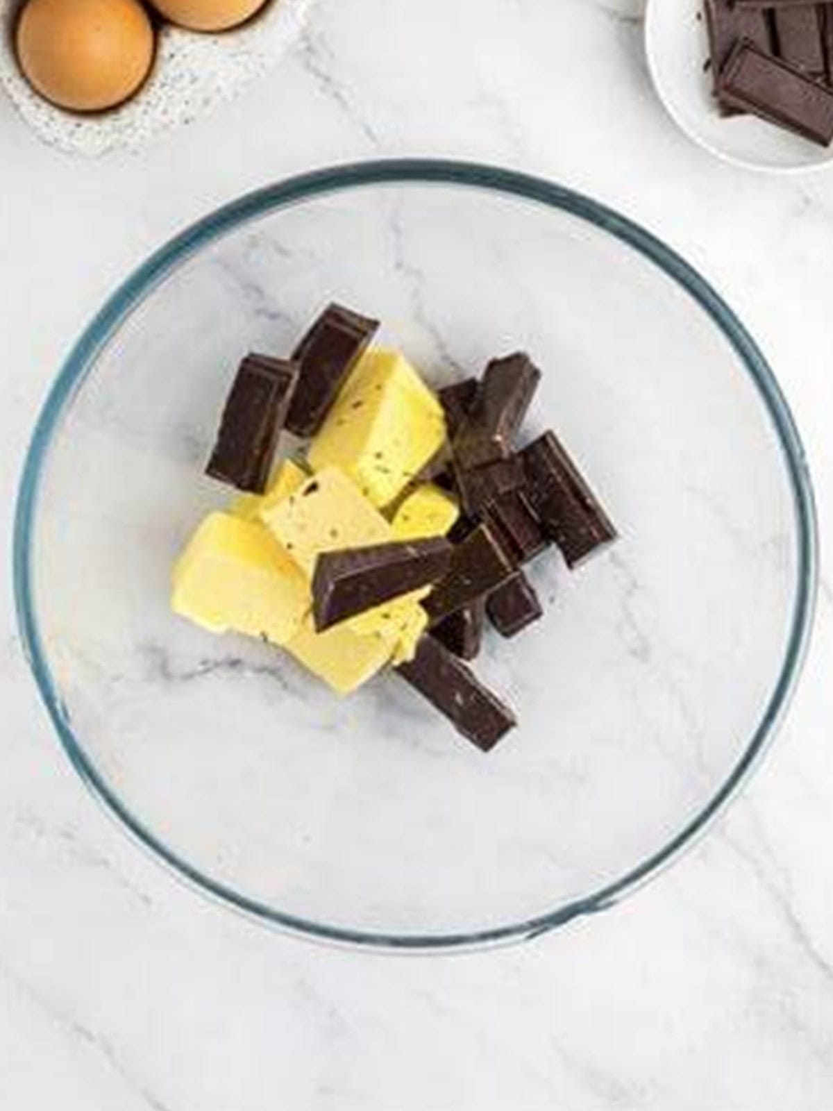 Butter and semi-sweet chocolate in a glass bowl ready to melt for sweet potato brownies.