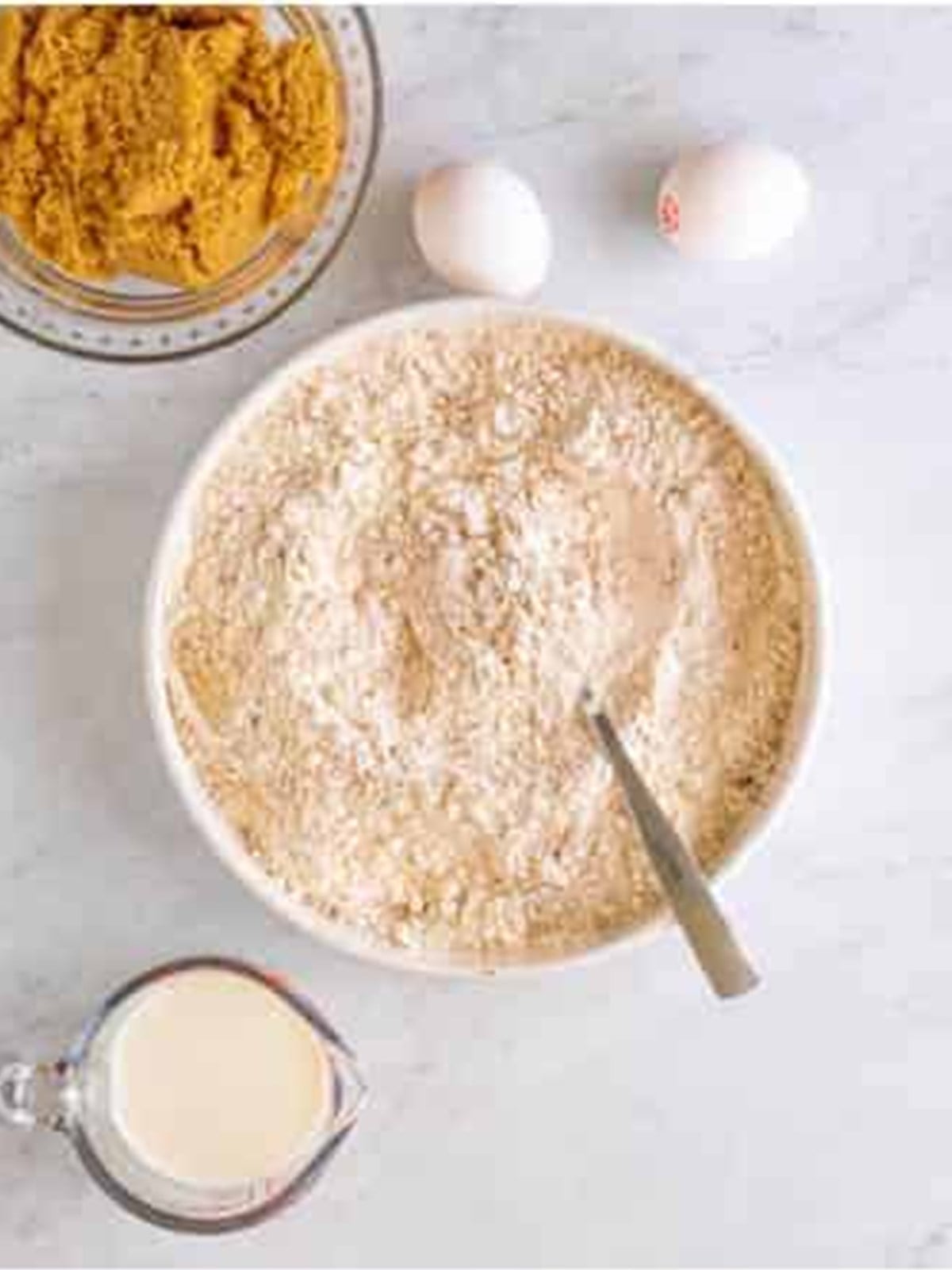 Flour, baking powder, and pumpkin pie spice whisked together in a bowl.