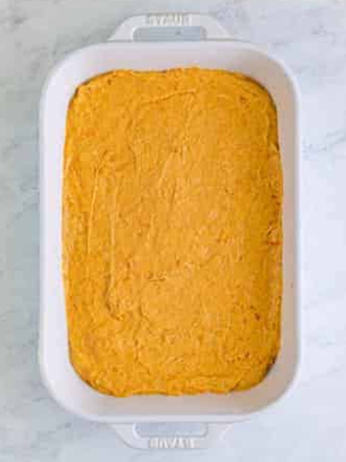 Sweet potato cake batter smoothed into a 9 by 13 baking dish.