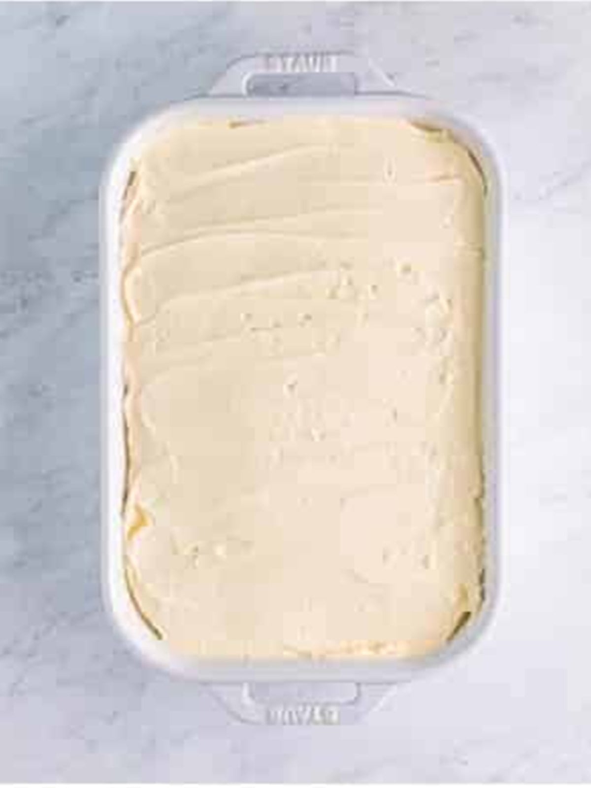 Sweet potato cake frosted with maple frosting in the baking dish.