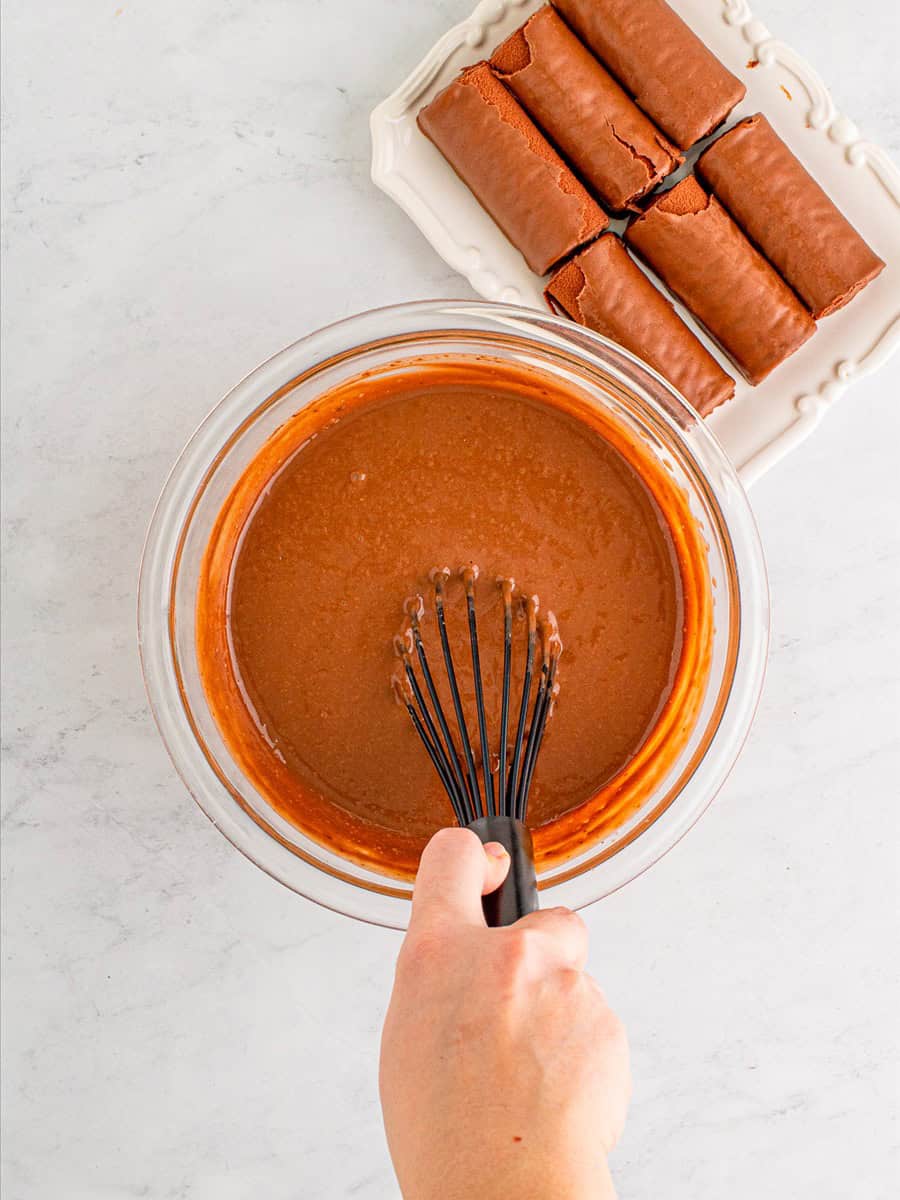 Whisking instant chocolate pudding with cold milk in a bowl.