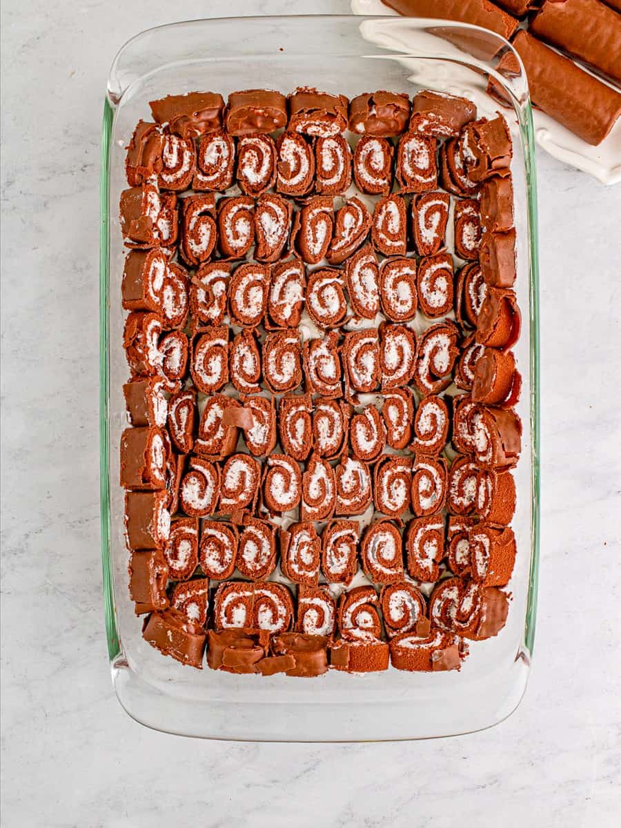 Cut swiss cake rolls layered cut-side up in the baking dish.