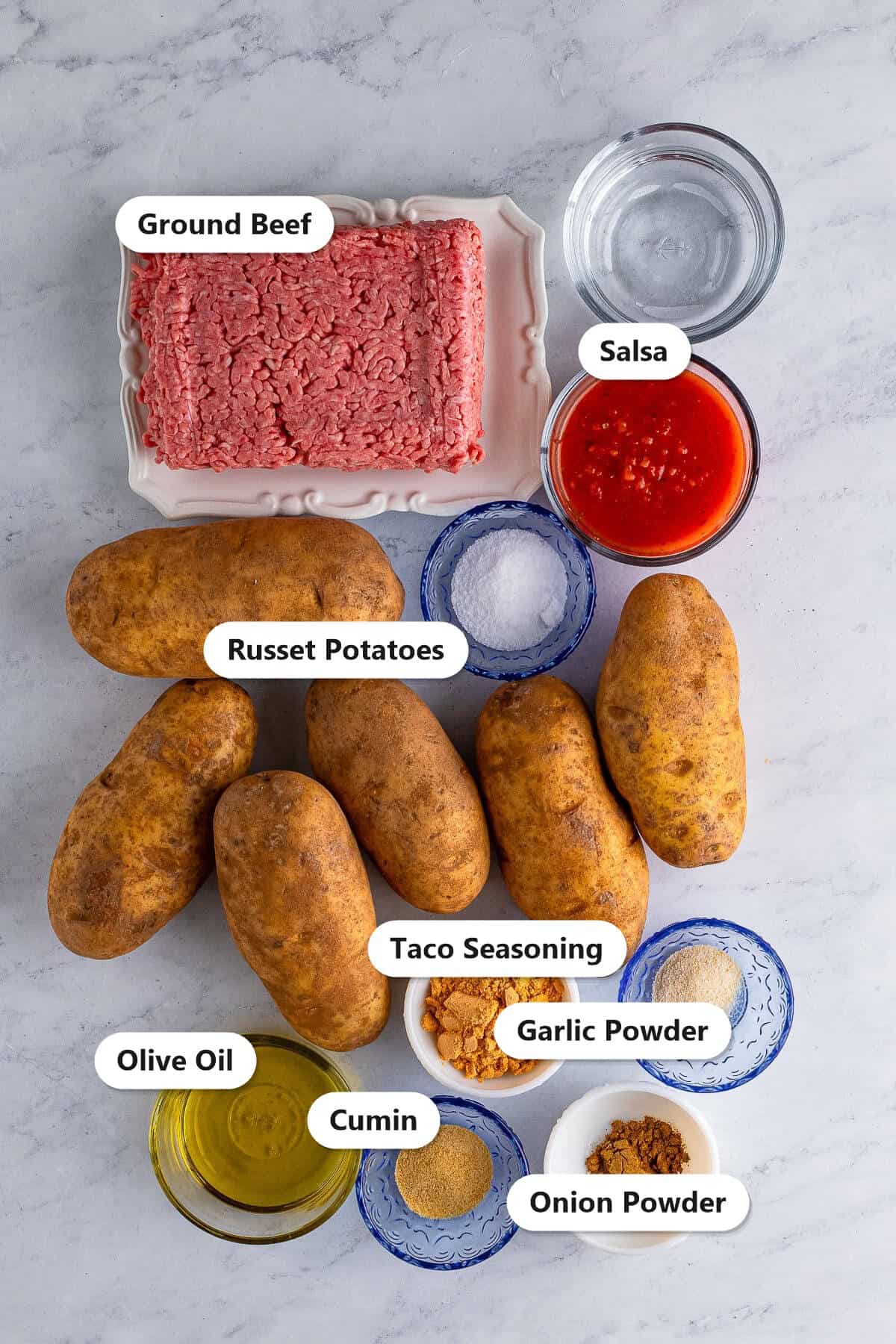 Labeled ingredients for taco baked potatoes including russet potatoes, ground beef, salsa, olive oil, taco seasoning, and spices.