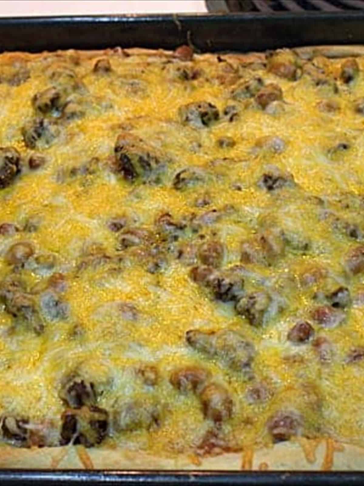 A baked taco pizza with golden melted cheese fresh from the oven.