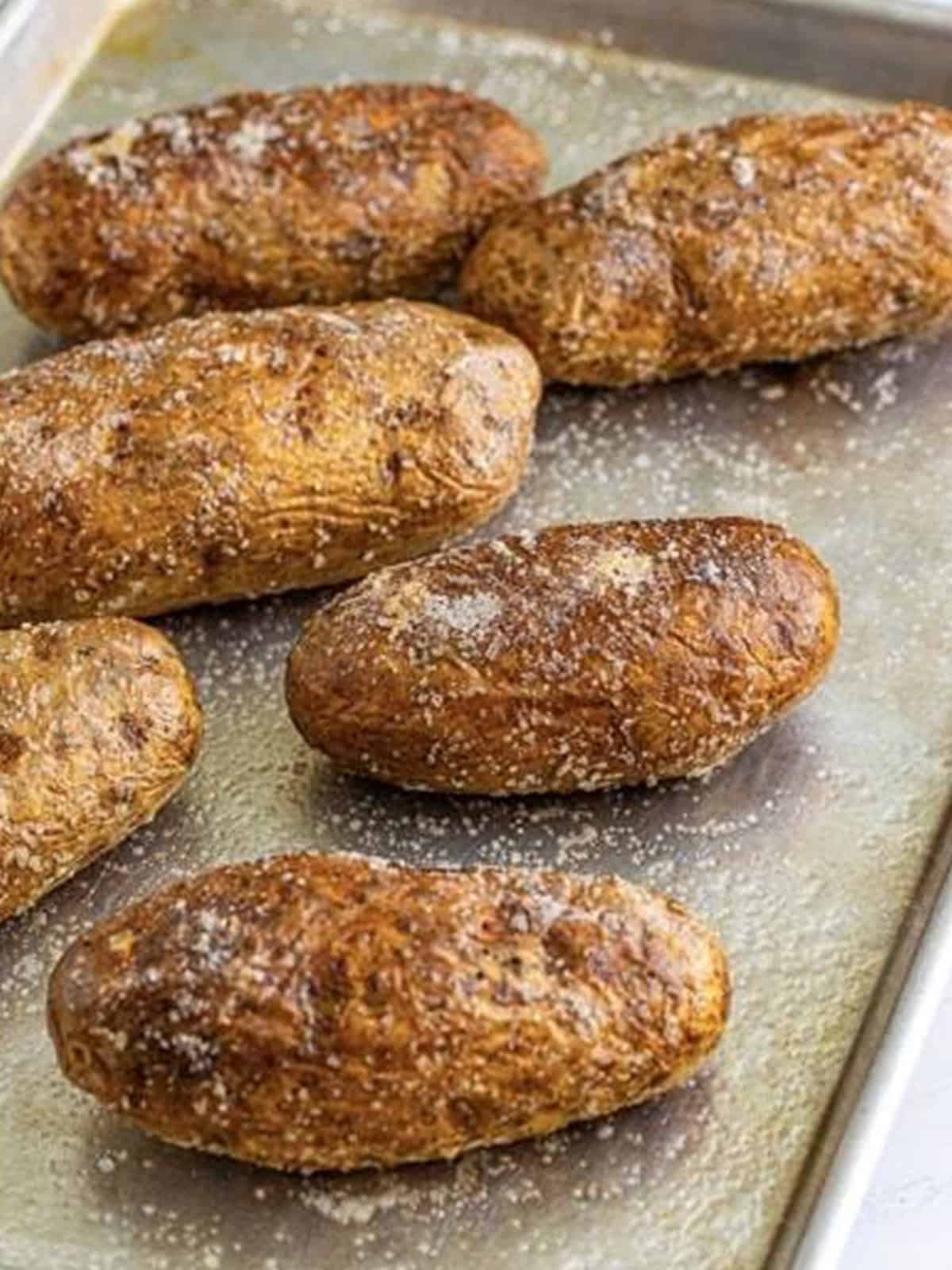 Golden baked russet potatoes on a baking tray.