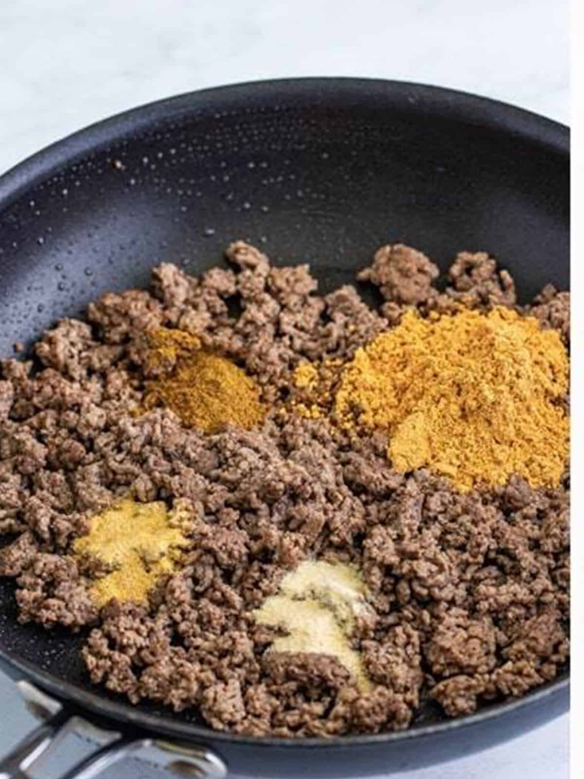 Browned ground beef with taco seasoning in a skillet.