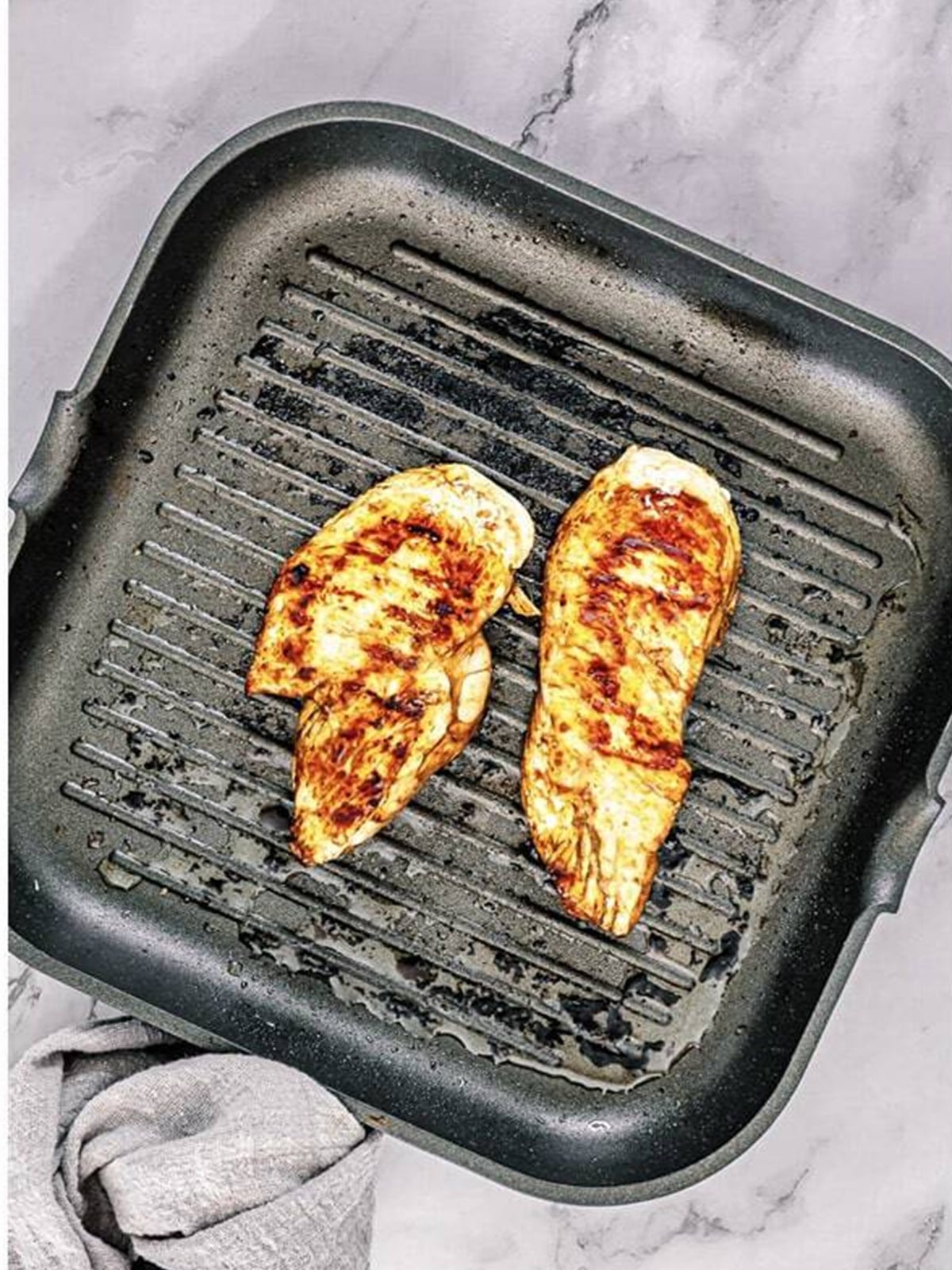 Grilled teriyaki chicken on a grill pan before dicing.
