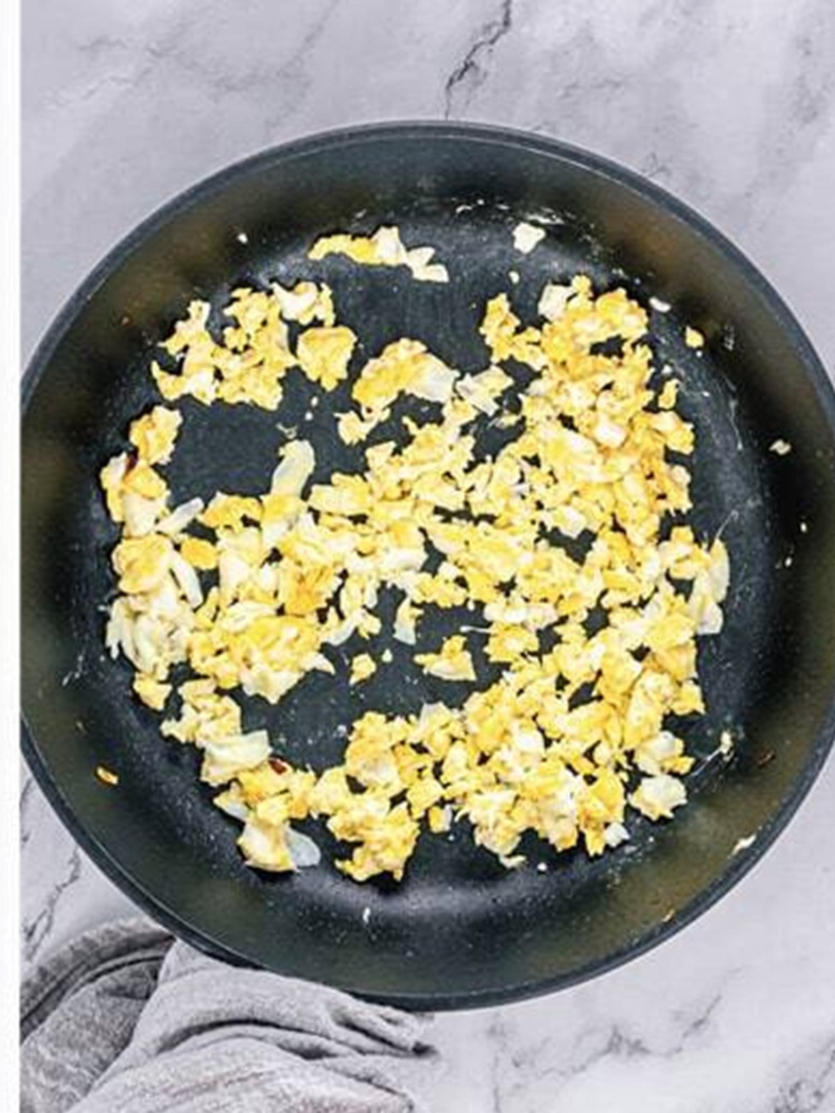 Scrambled eggs cooking in the skillet for fried rice.