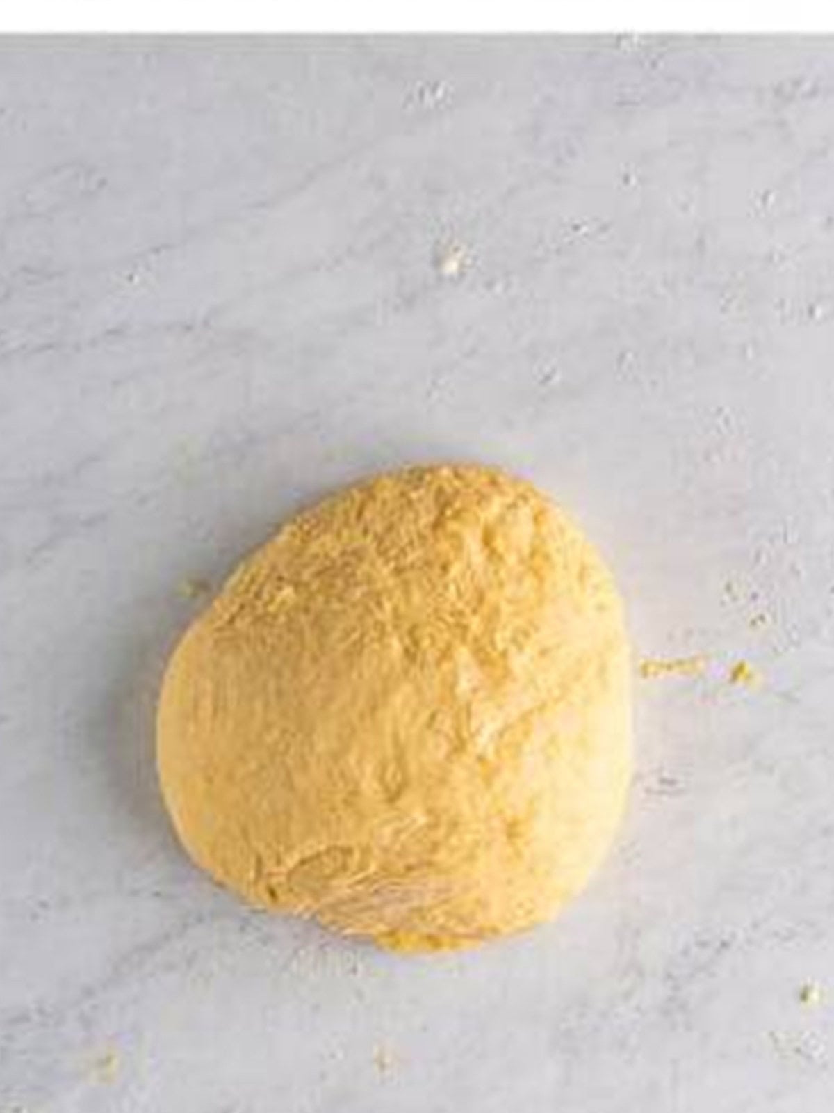 A smooth ball of soft Texas Roadhouse roll dough kneaded on a counter.
