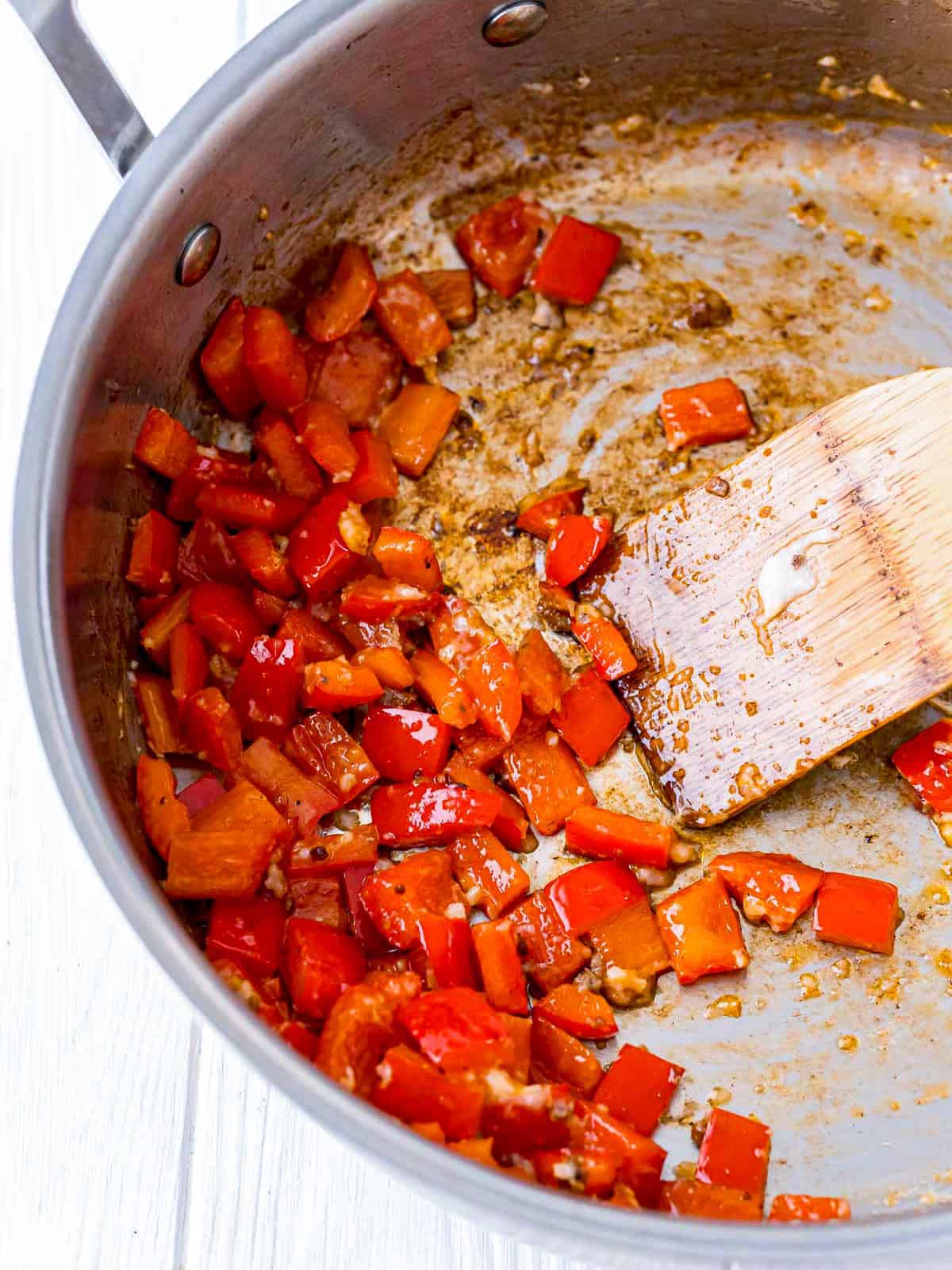 Red pepper, garlic, and sauce added to the skillet for Thai beef.