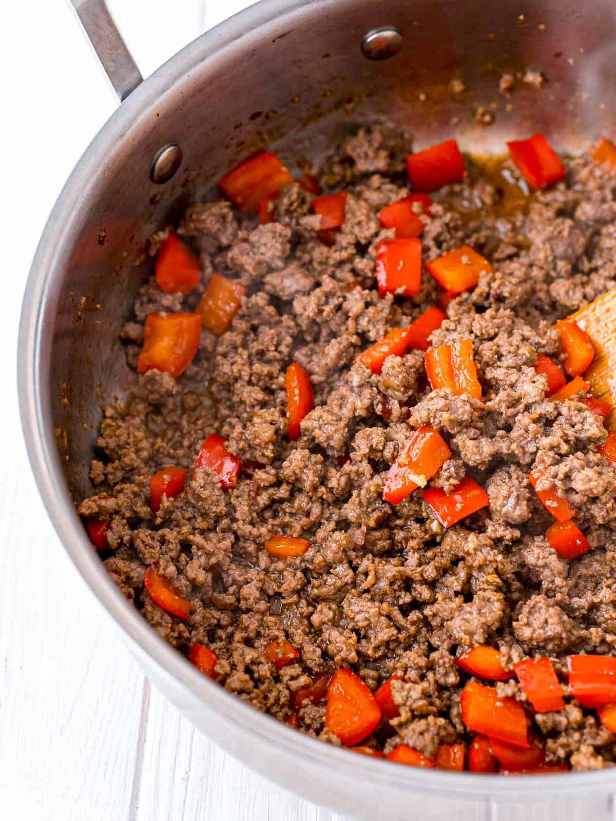 Thai beef cooking down in the skillet until the liquid evaporates.