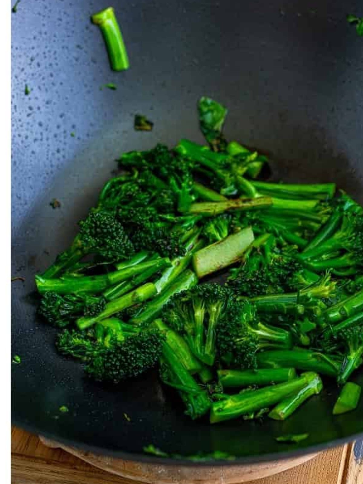Broccolini charred in a hot wok for pad see ew.