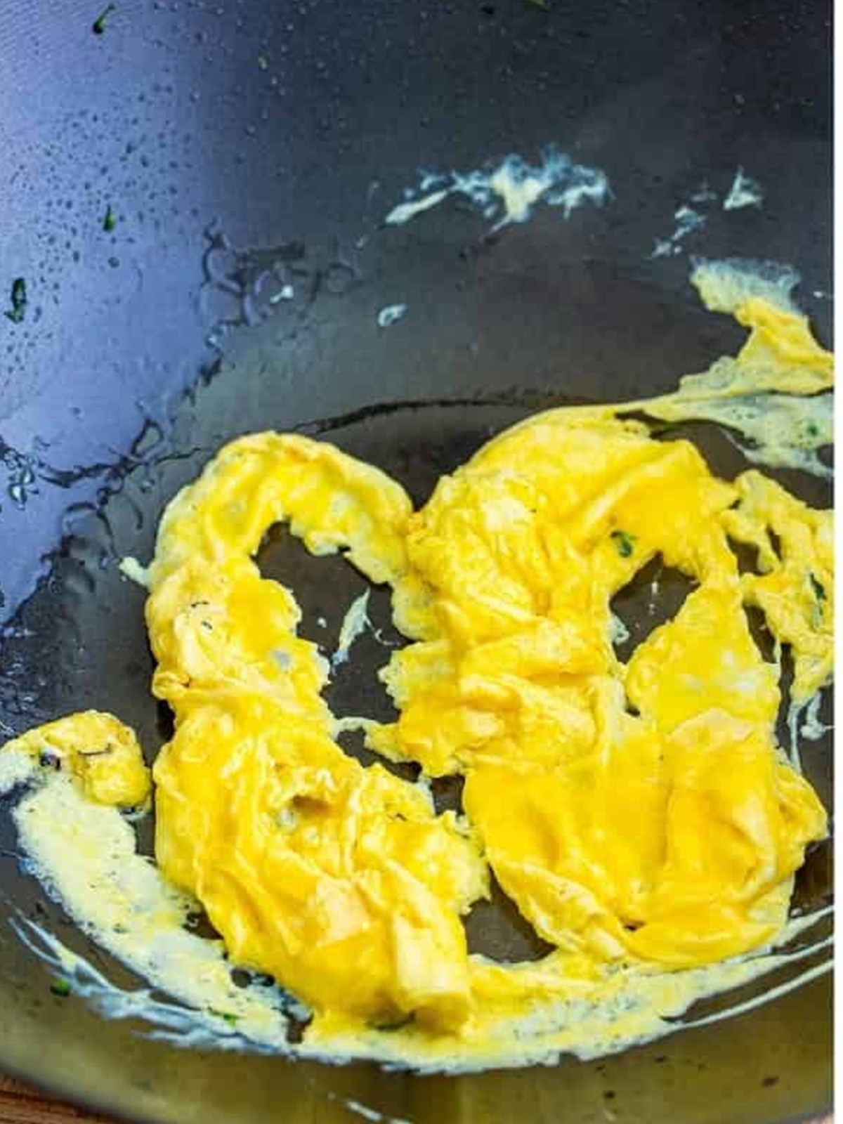Eggs scrambled in a wok for pad see ew.
