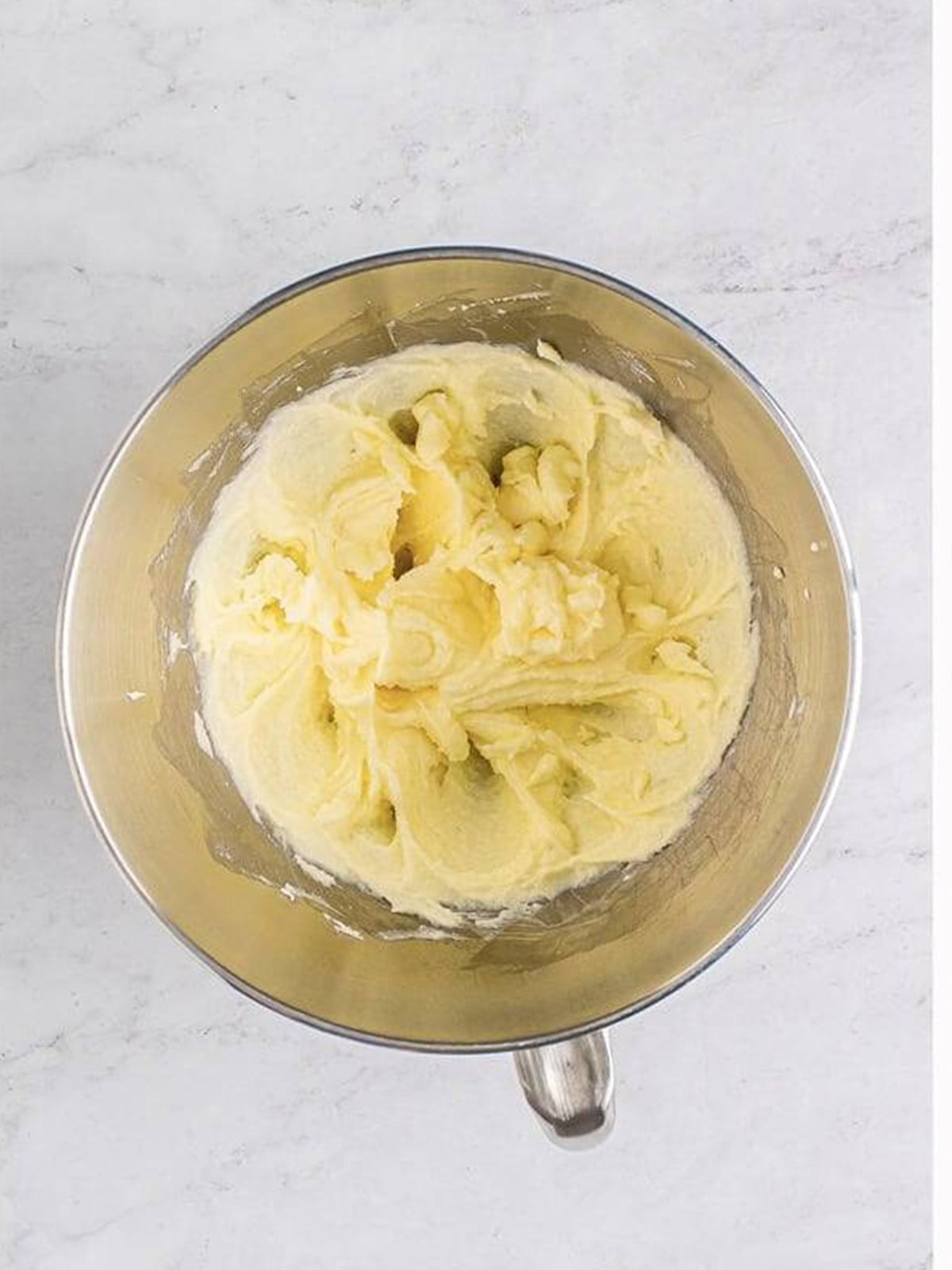 Butter and sugar creamed together in a stand mixer bowl for thumbprint cookies.
