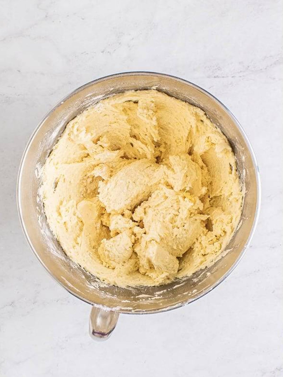 Soft thumbprint cookie dough mixed together in a stand mixer bowl.