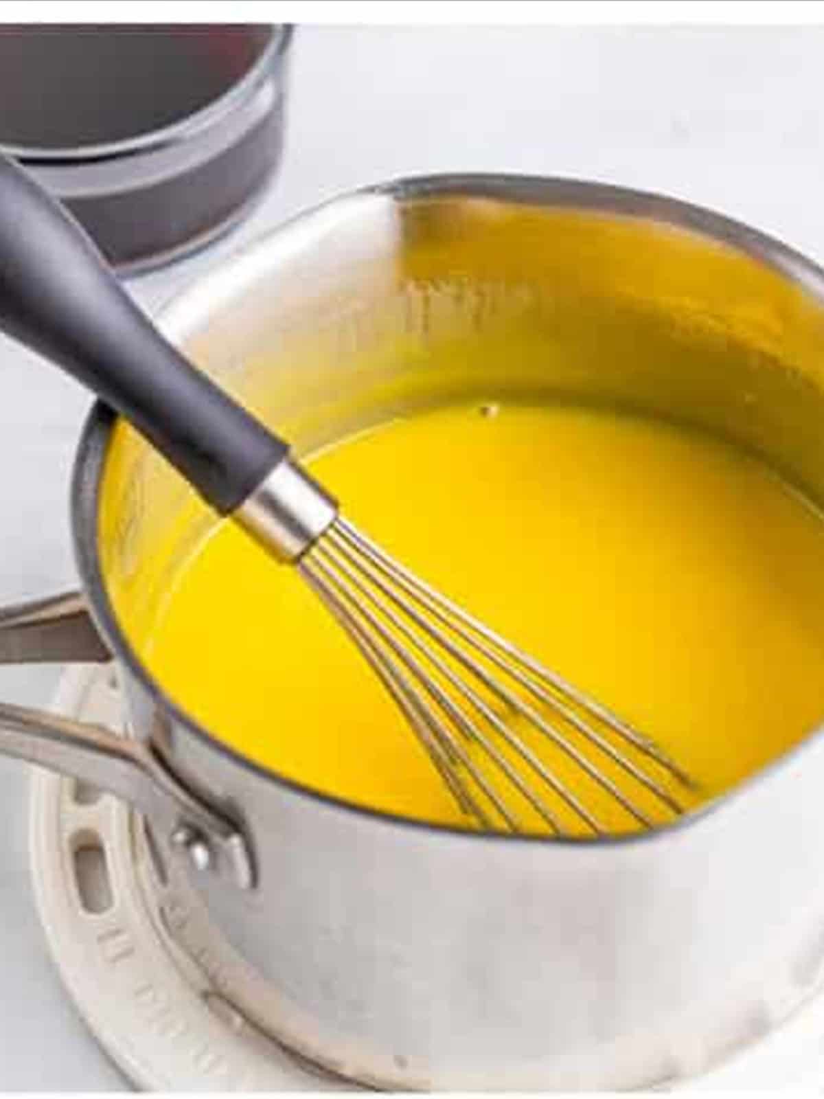 Whisking egg yolks and sugar in a saucepan for tiramisu recipe custard.