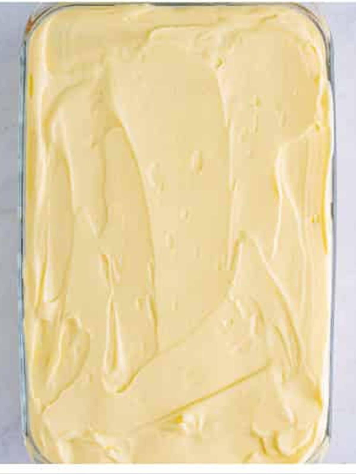 Smoothing the final cream layer over the tiramisu recipe.