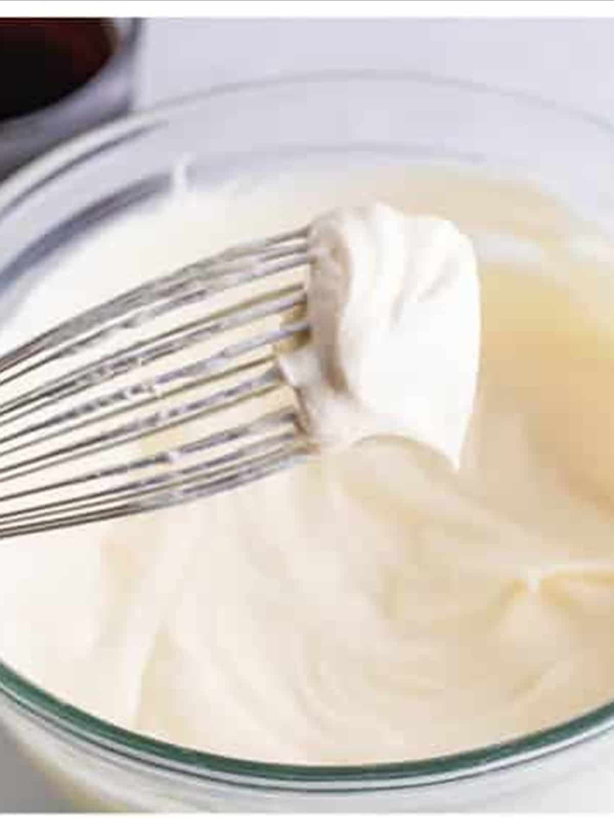 Whipped cream forming stiff peaks for tiramisu recipe.