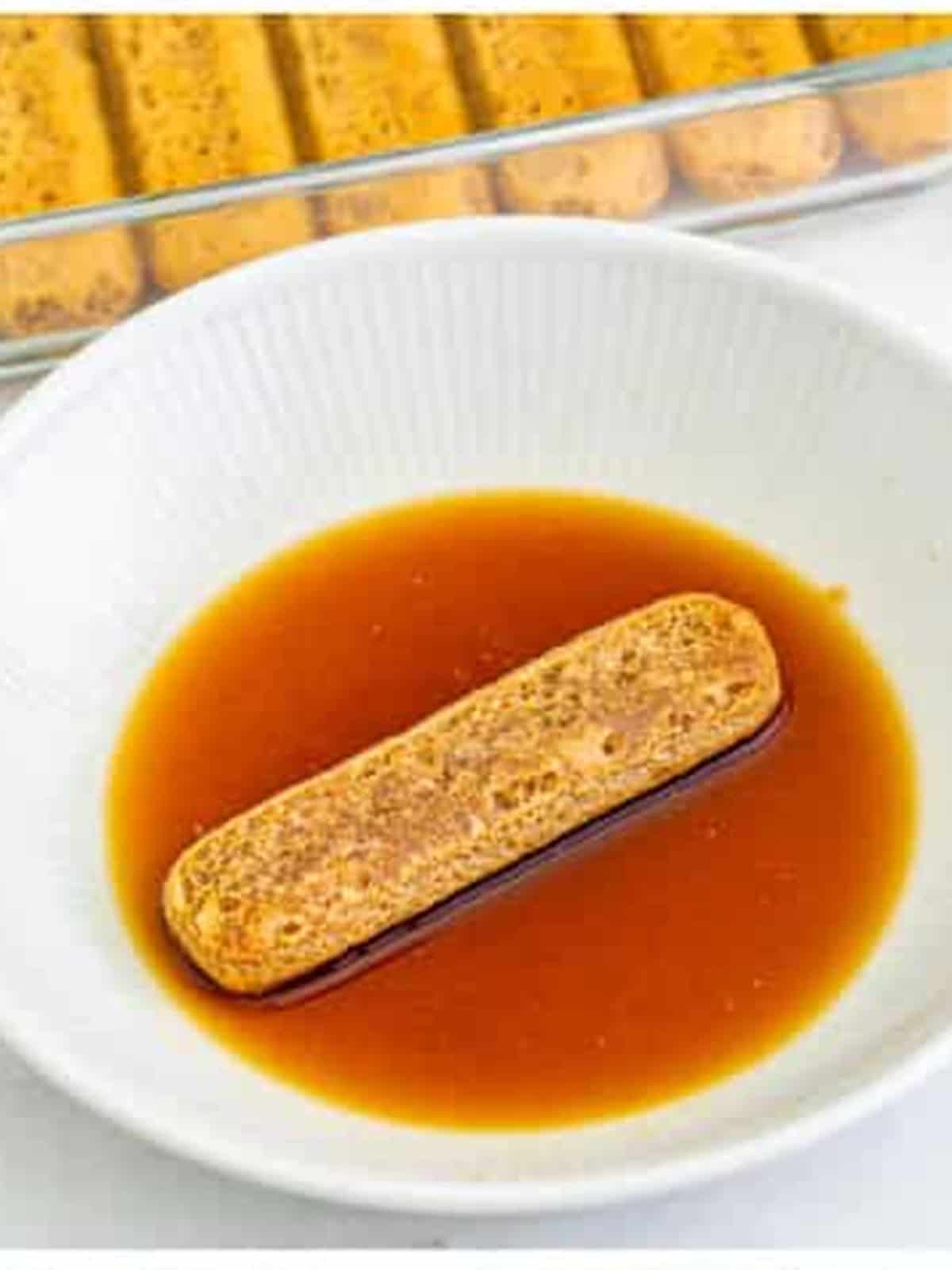 Dipping a lady finger in coffee and Kahlua for tiramisu recipe.