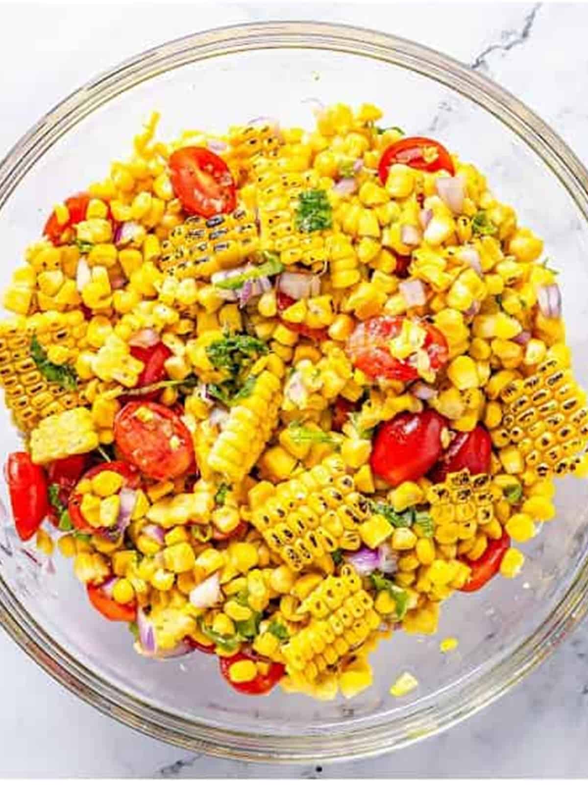 Finished corn and tomato salad tossed with vinaigrette and fresh basil.