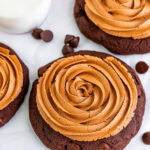 A triple chocolate cookie topped with a swirled chocolate fudge frosting rosette.