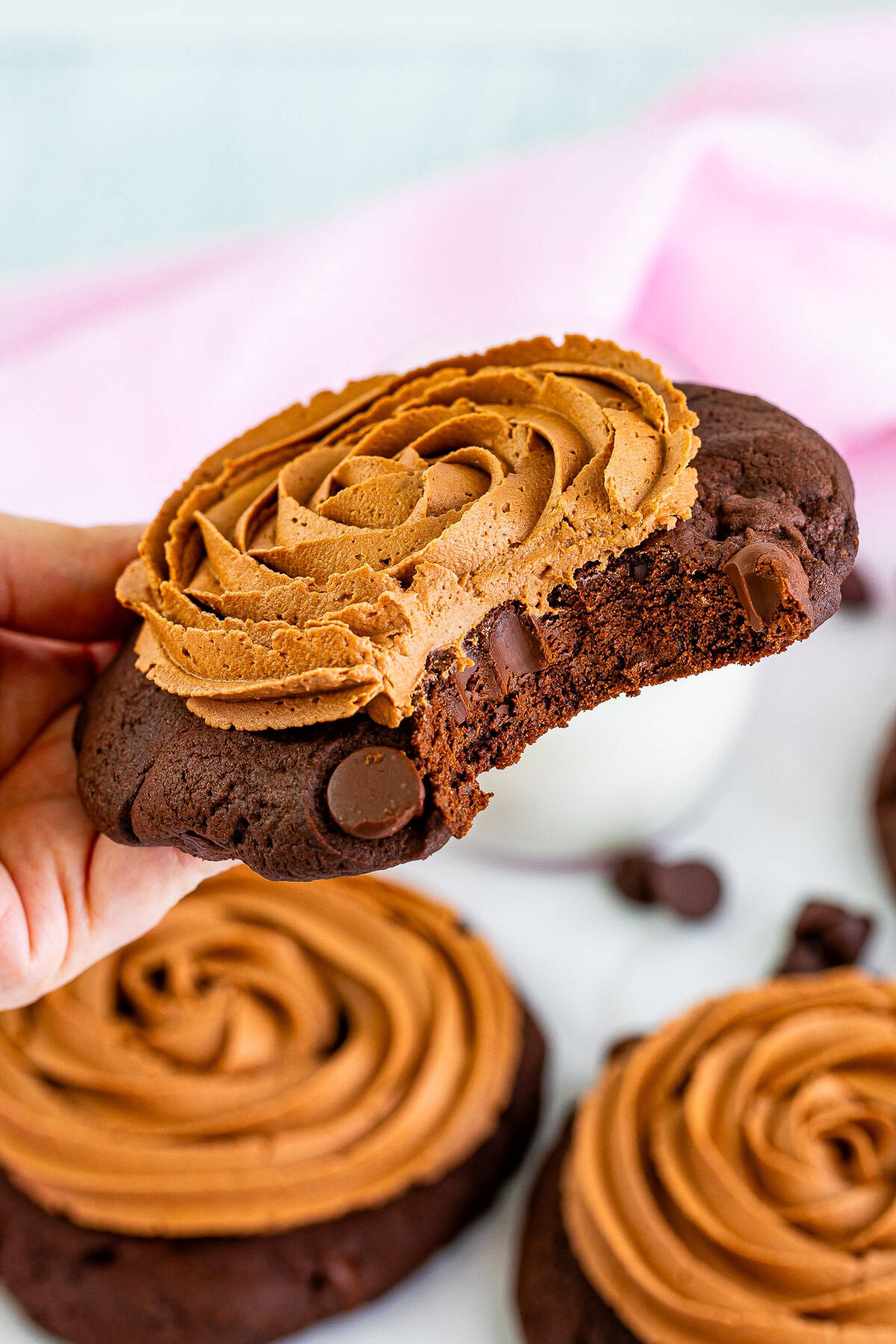 A triple chocolate cookie with a bite taken out showing the fudgy chocolate interior.