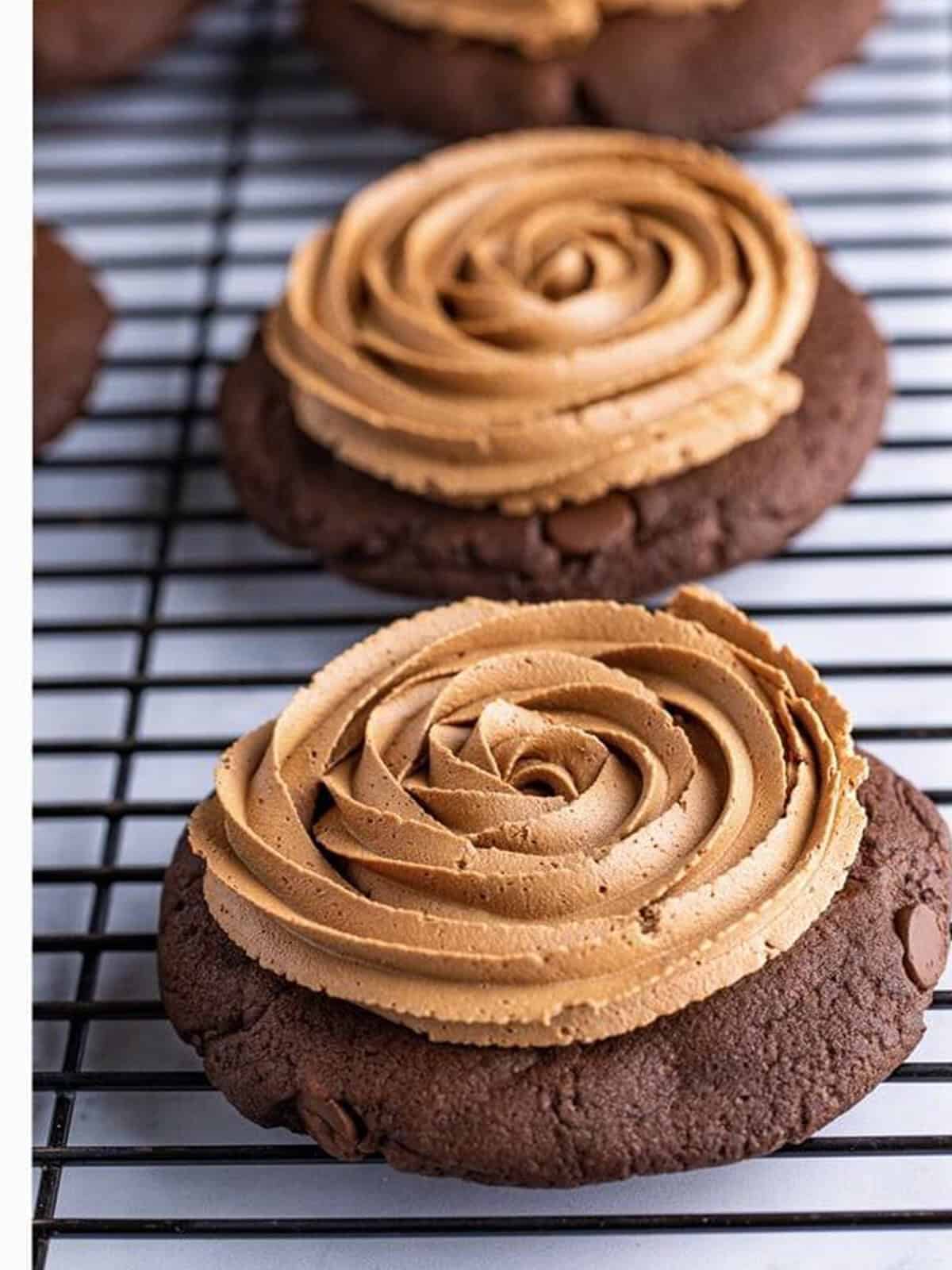 A chocolate fudge frosting rosette piped onto a triple chocolate cookie.
