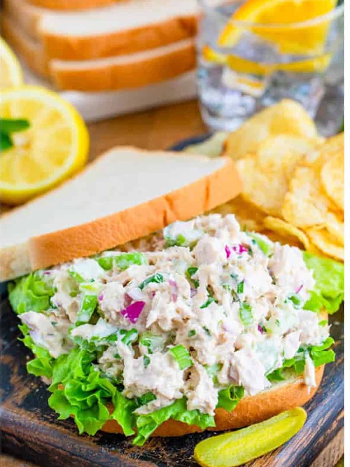 Tuna salad piled on white bread with lettuce to build a tuna salad sandwich.