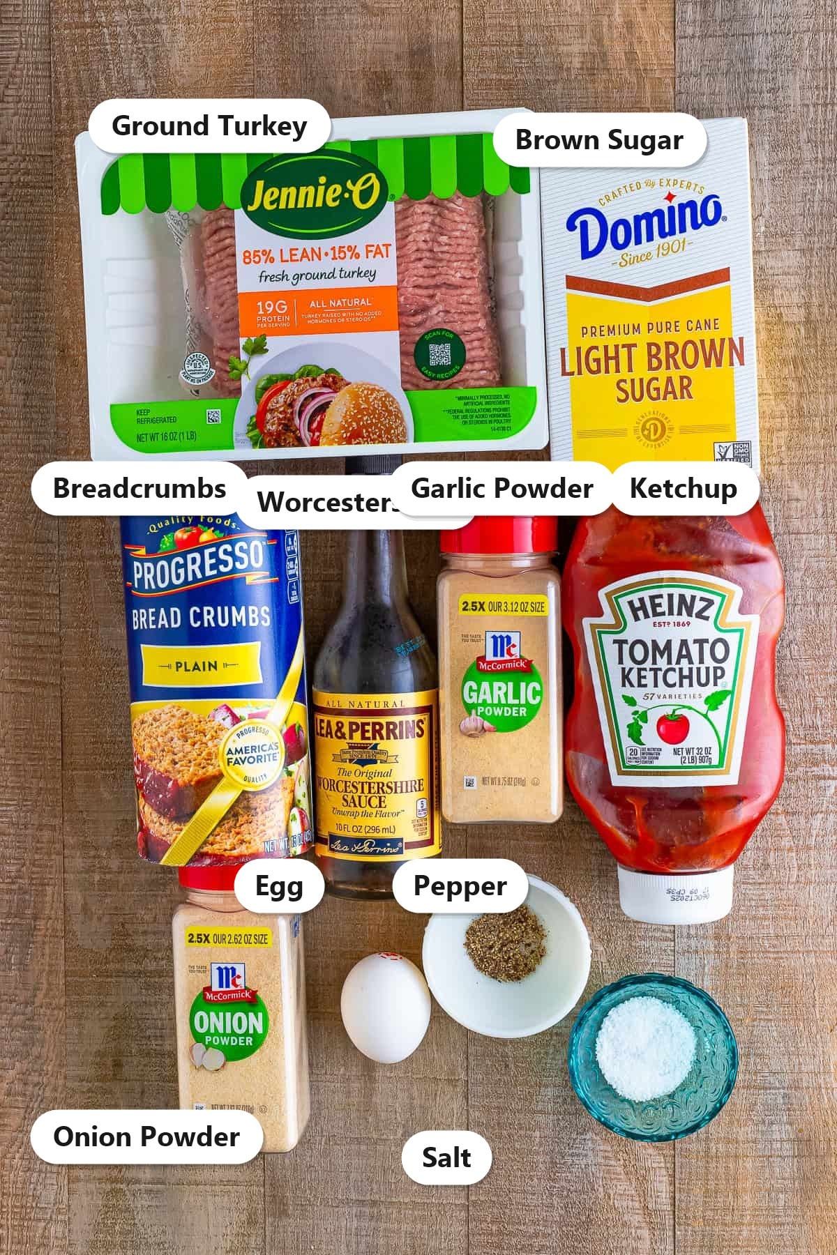 Labeled turkey burger ingredients including ground turkey, ketchup, Worcestershire, brown sugar, breadcrumbs, egg, and spices on a wooden board.