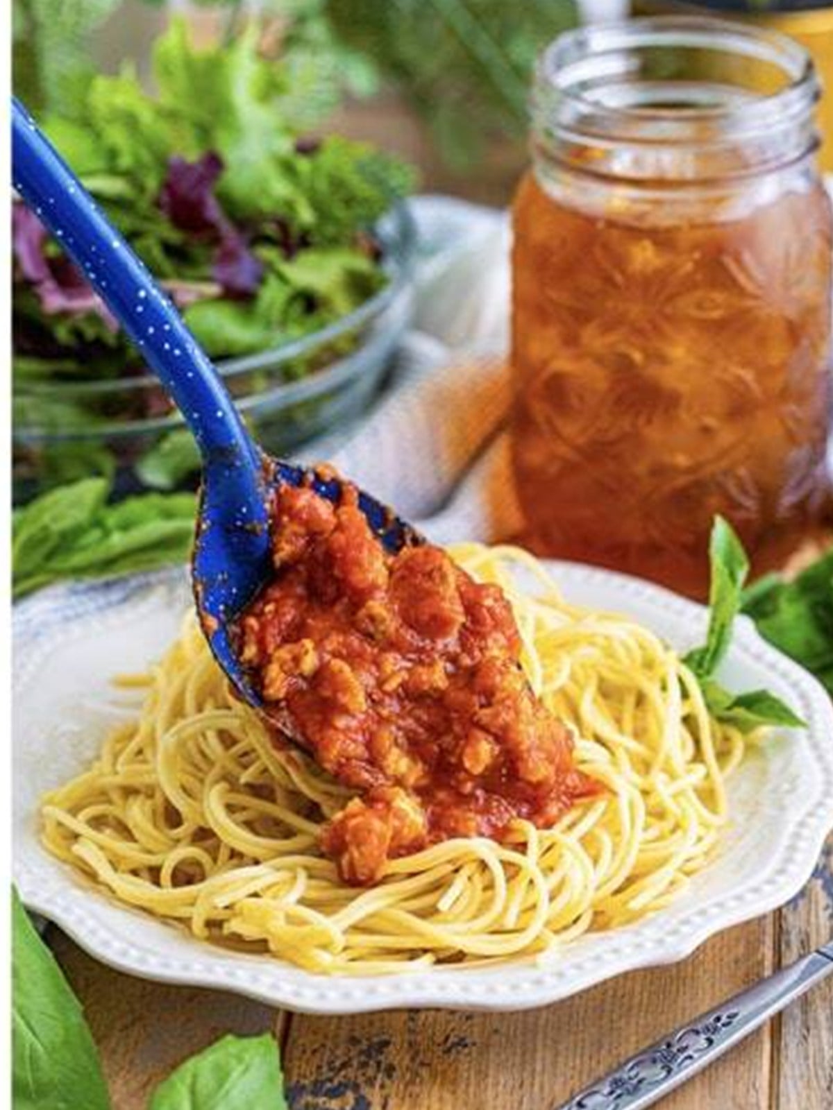 Ground turkey meat sauce spooned over a plate of spaghetti.