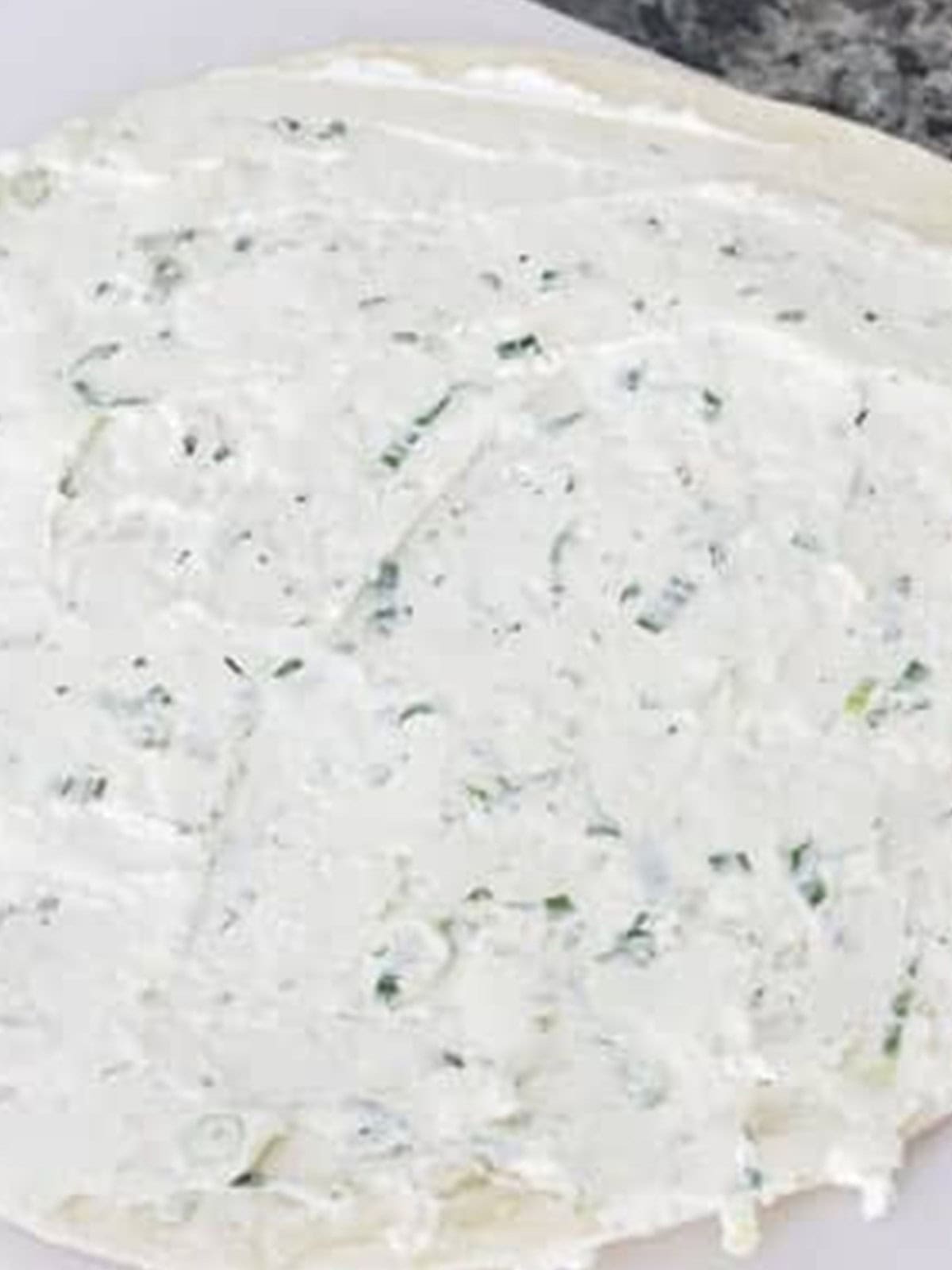 Herbed cream cheese mixture spread evenly over large tortillas.