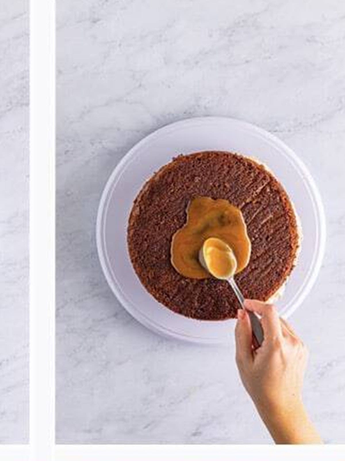 A chocolate cake layer poked with holes, soaked in caramel, and spread with caramel pecan frosting.