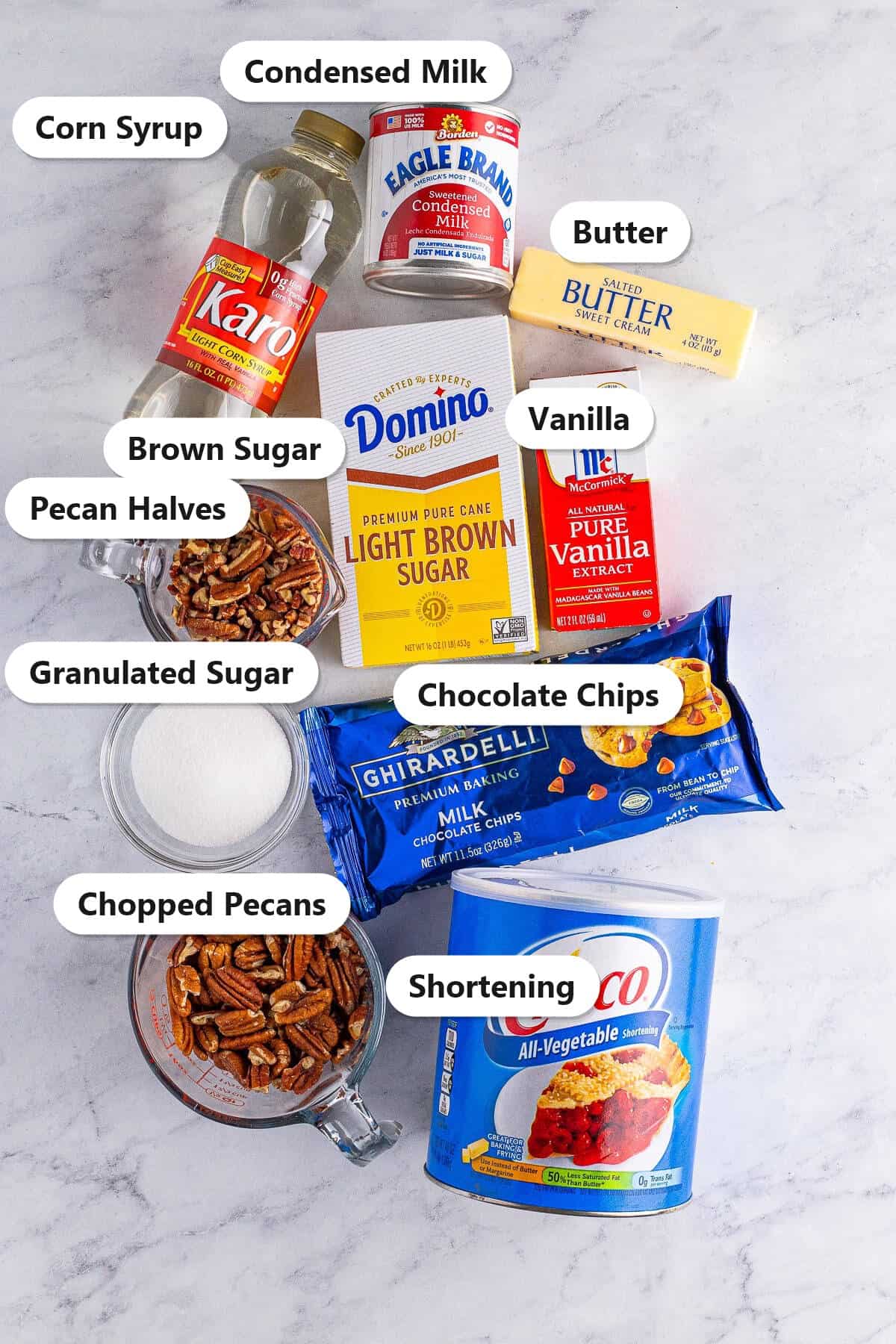 Labeled ingredients for turtle candy including pecans, butter, brown sugar, corn syrup, condensed milk, chocolate chips, and shortening.