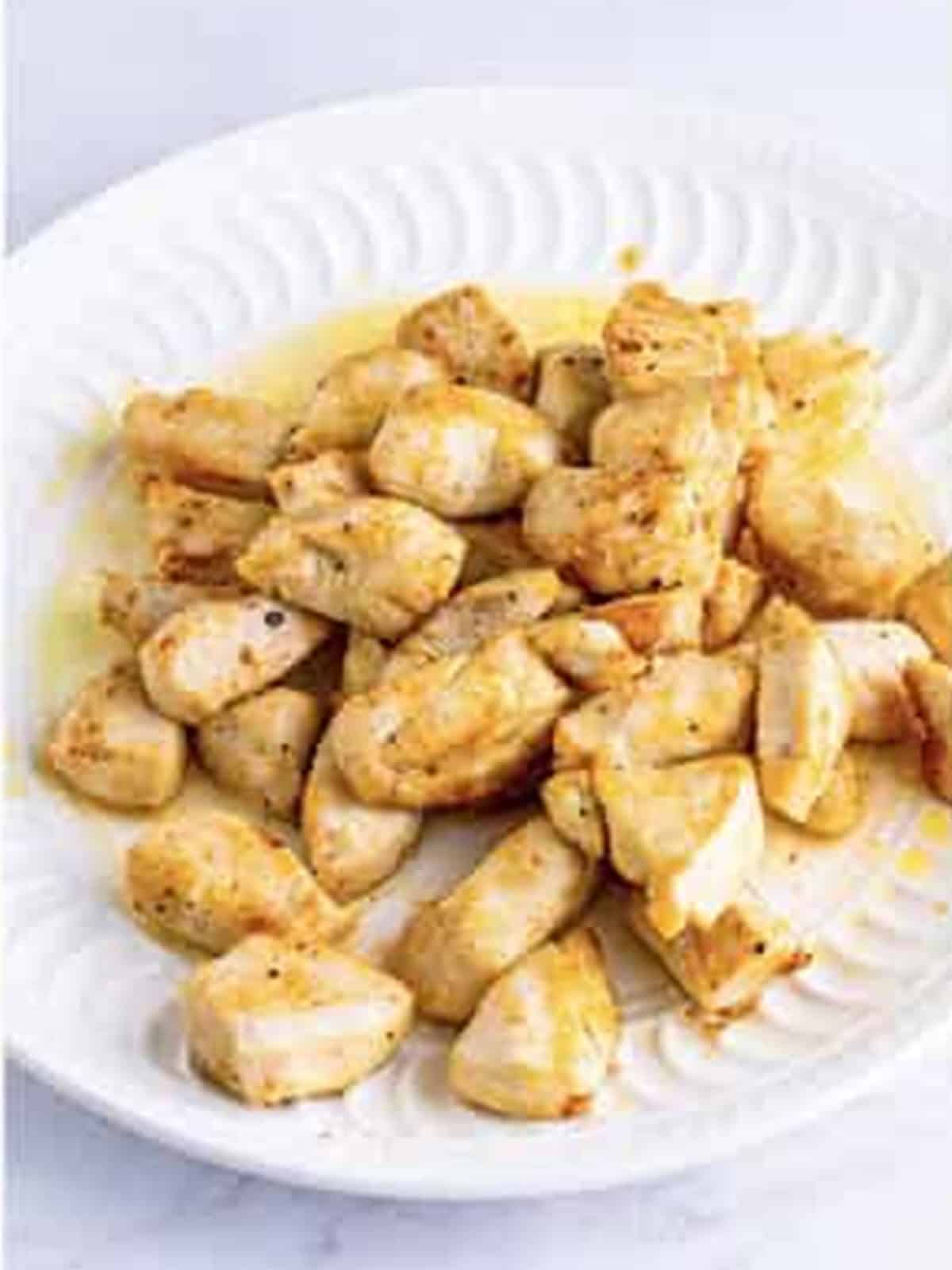 Golden browned chicken pieces on a white plate.